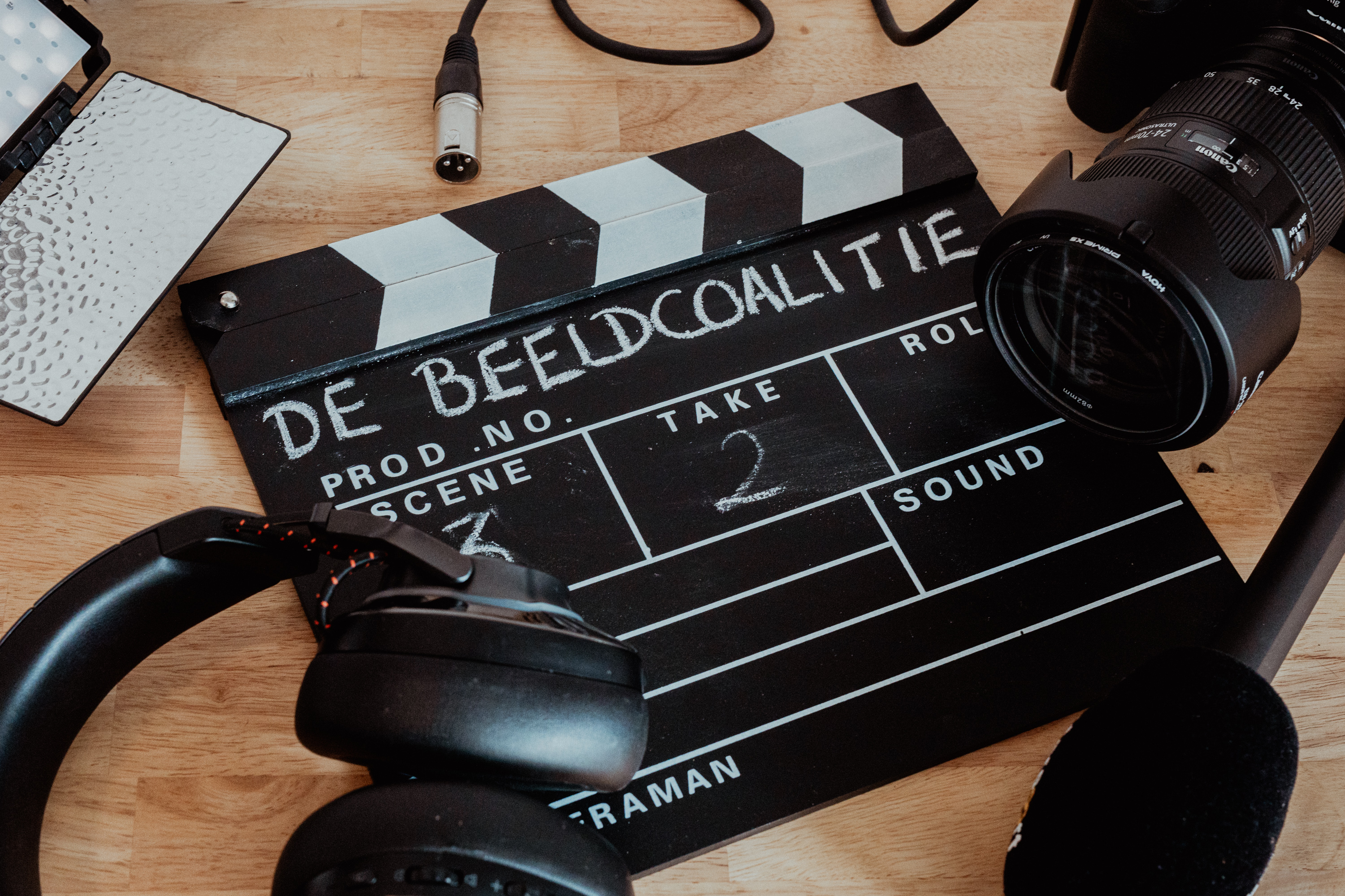 Clapperboard met tekst 'De Beeldcoalitie' en apparatuur voor film- en audiovisuele productie