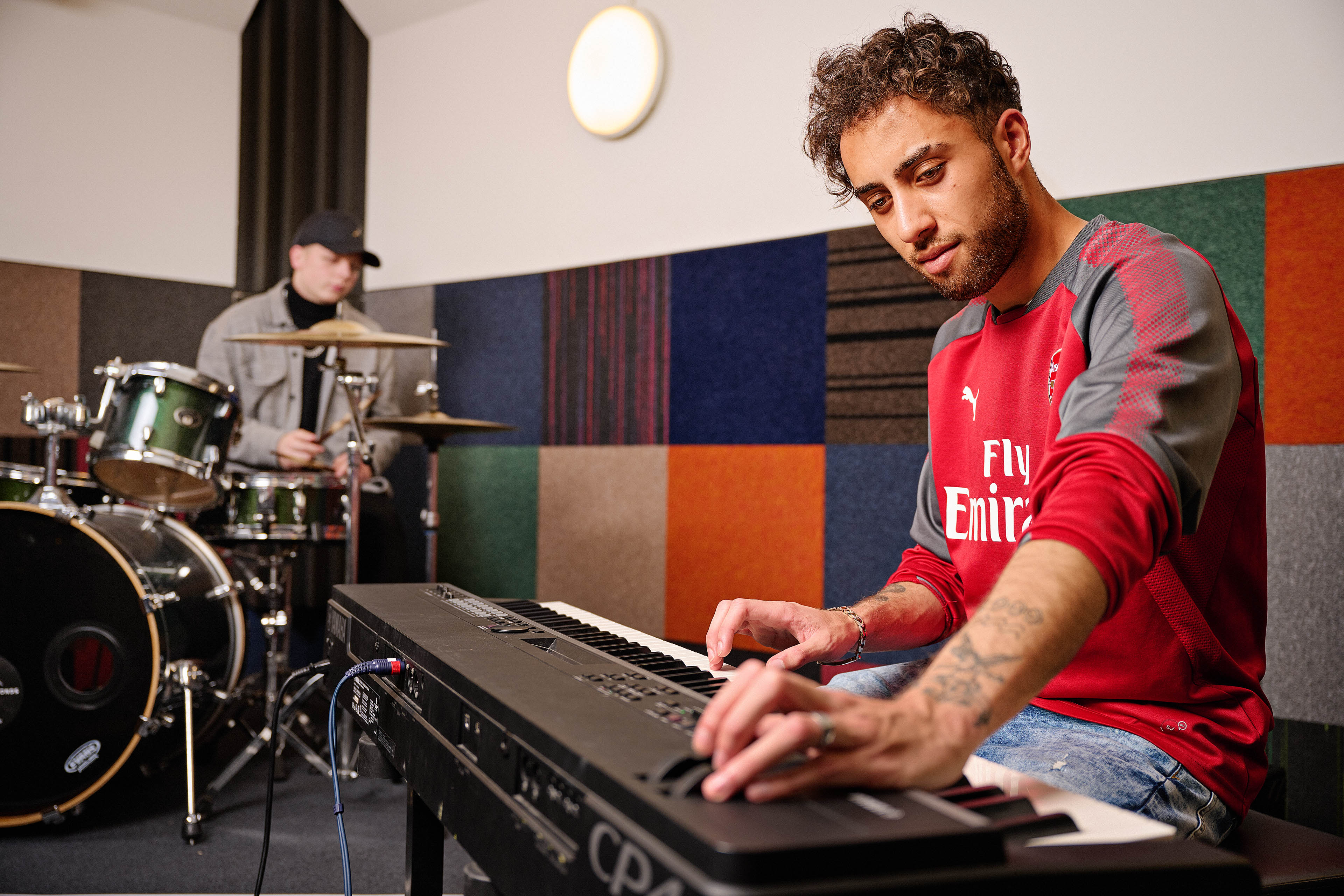 Student bespeelt keyboard tijdens muzieksessie in oefenruimte van Noorderpoort Impressfest.