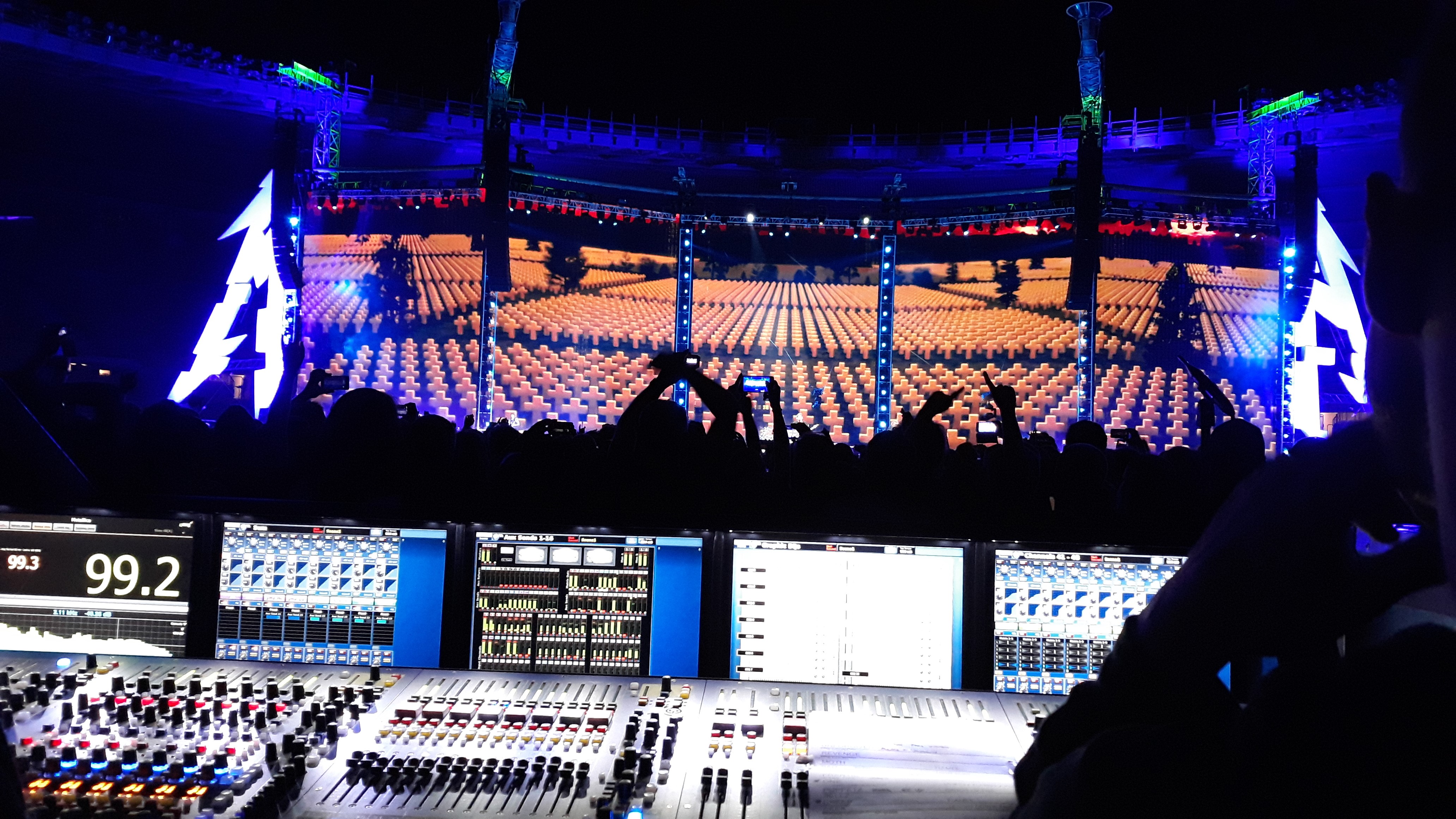 Technicus bedient mengenpaneel tijdens live evenement ondersteund door licht- en geluidstechniek