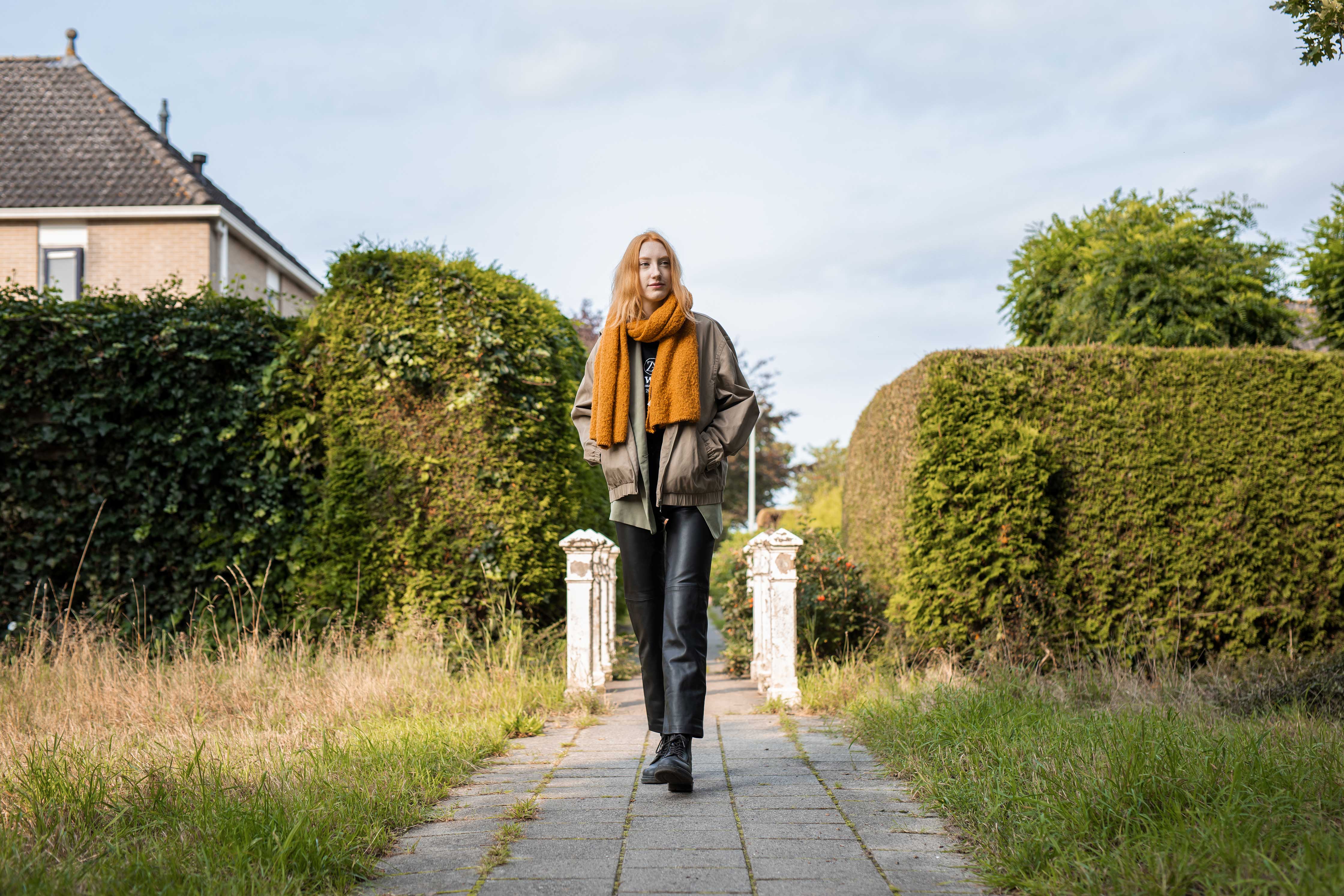 Student loopt op pad tussen hoge hagen, passend bij verhaal over mbo allround schoonheidsspecialist.