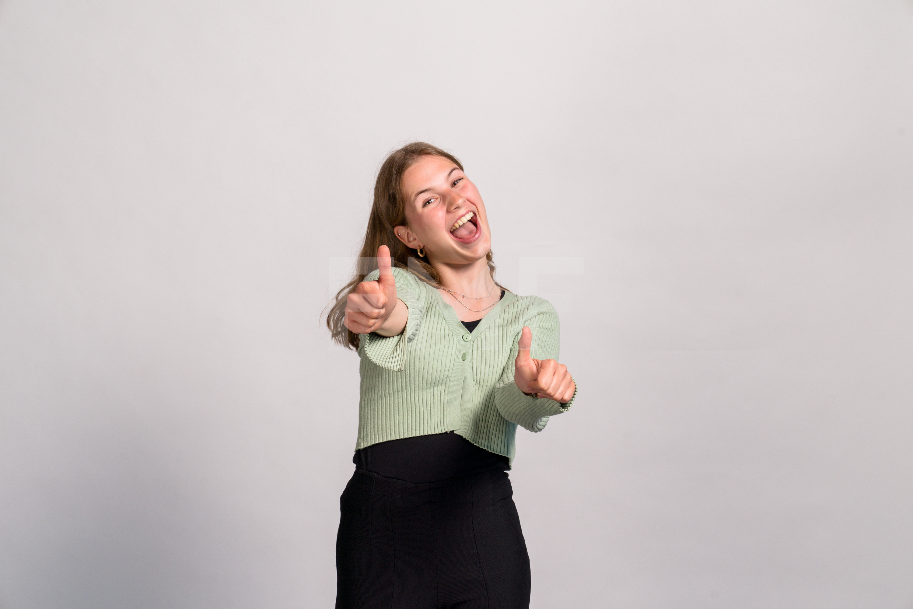 Een enthousiaste student geeft duimen omhoog als teken van motivatie en positieve toekomstperspectieven.
