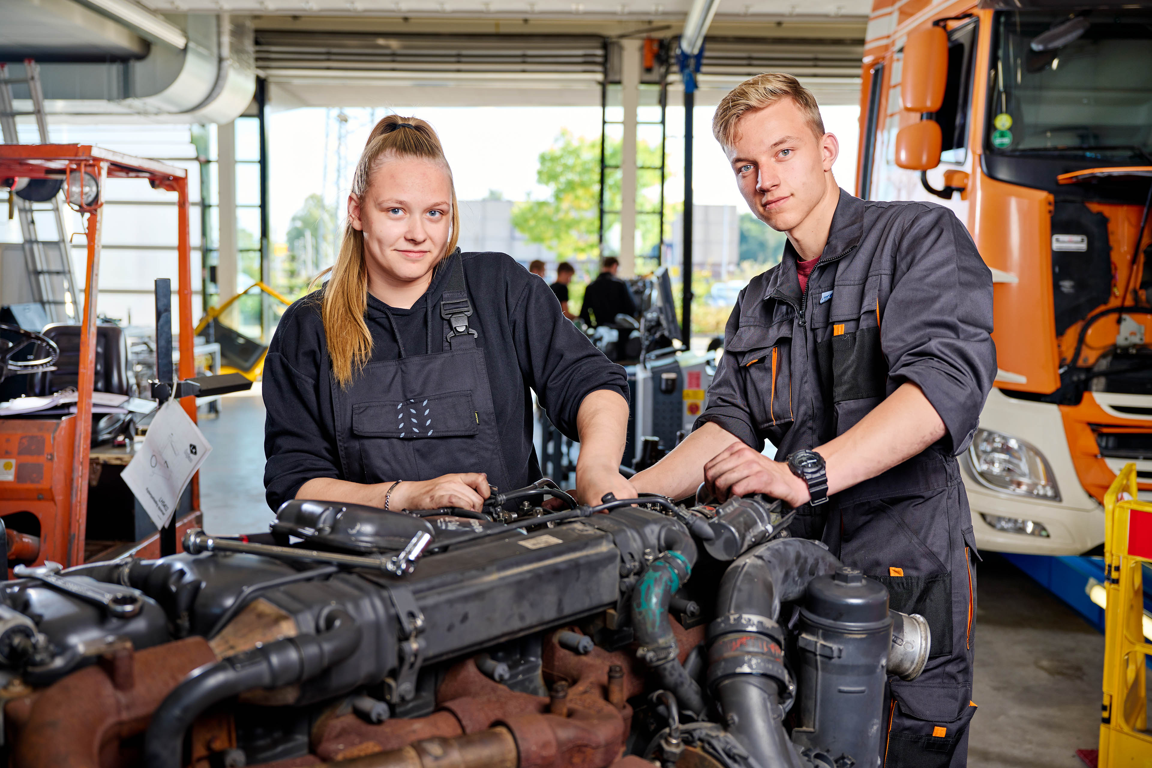 Twee studenten voeren onderhoud uit aan een motor in een werkplaats van Noorderpoort.