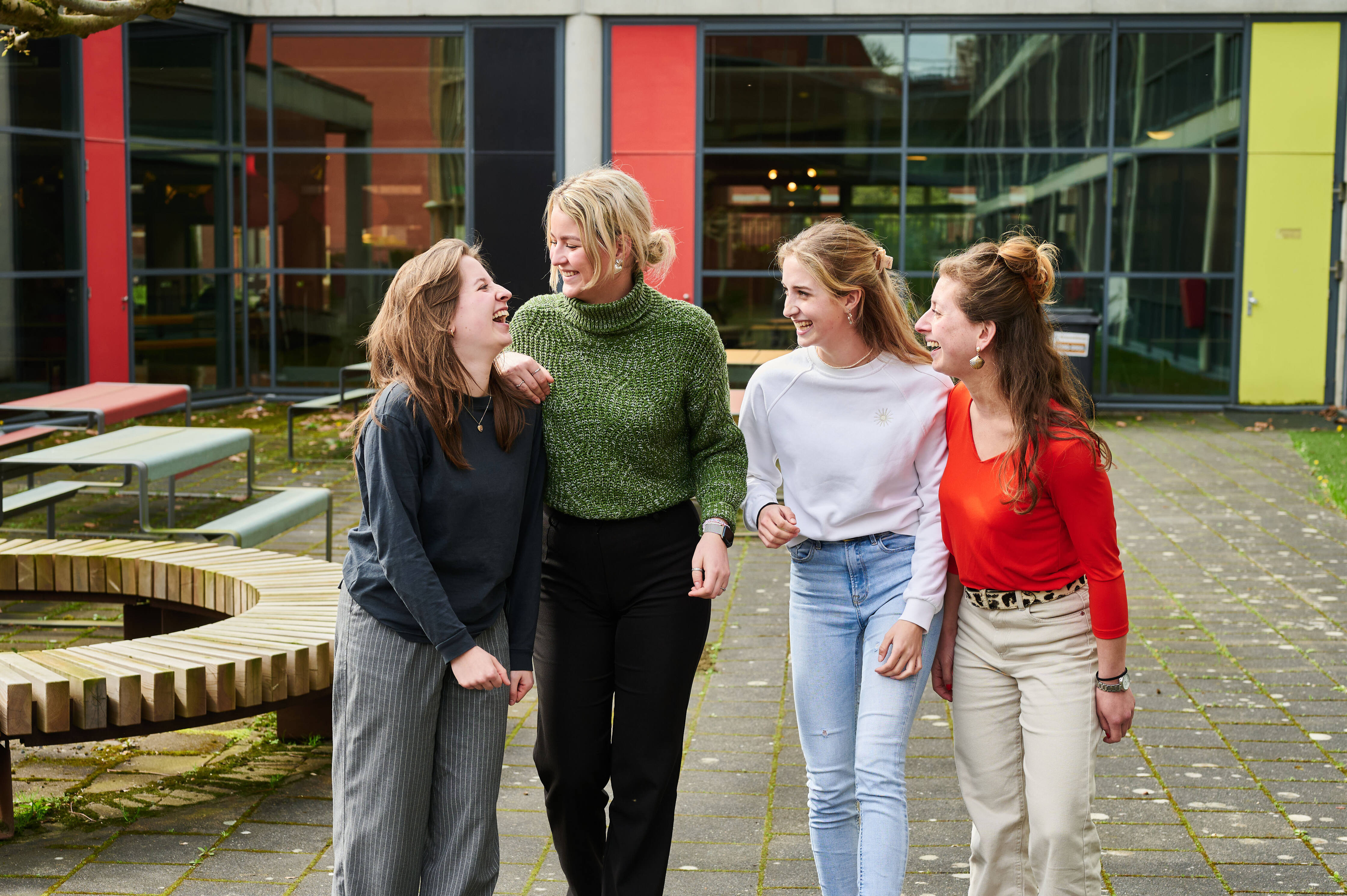 Vier studentes lopen samen over het schoolplein en wisselen ideeën uit bij Noorderpoort