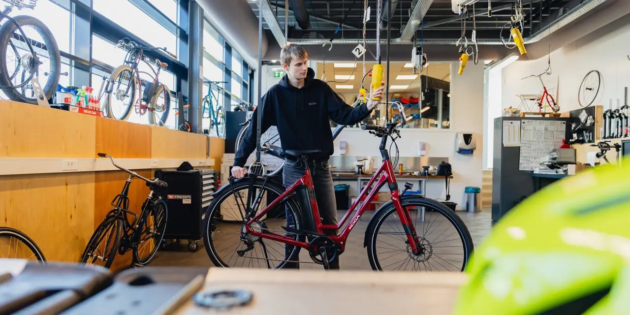 Student werkt aan een elektrische fiets in een praktijkruimte voor fietstechniek bij Noorderpoort