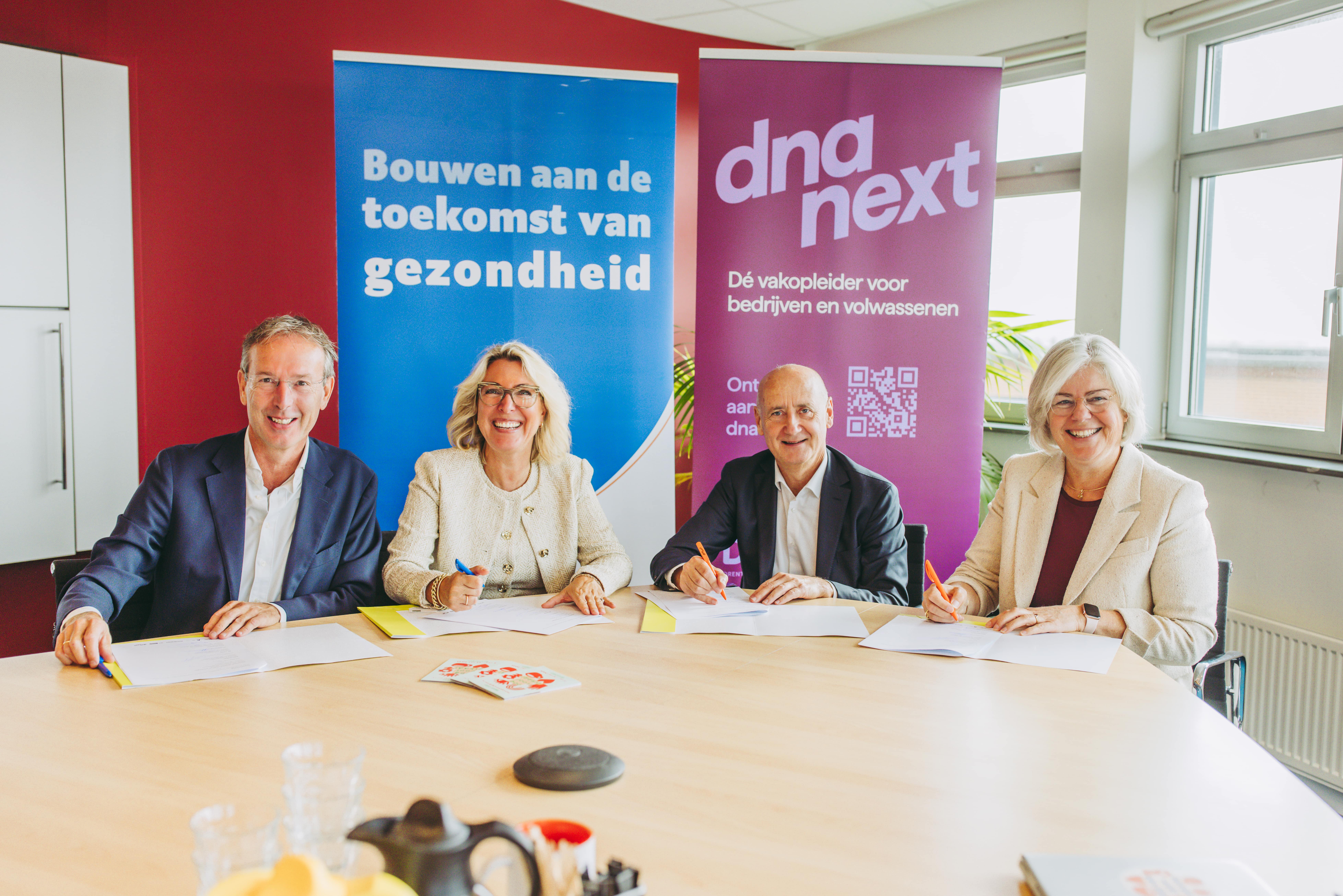 Vier vertegenwoordigers ondertekenen een samenwerking voor toekomstbestendige zorg en gezondheid.