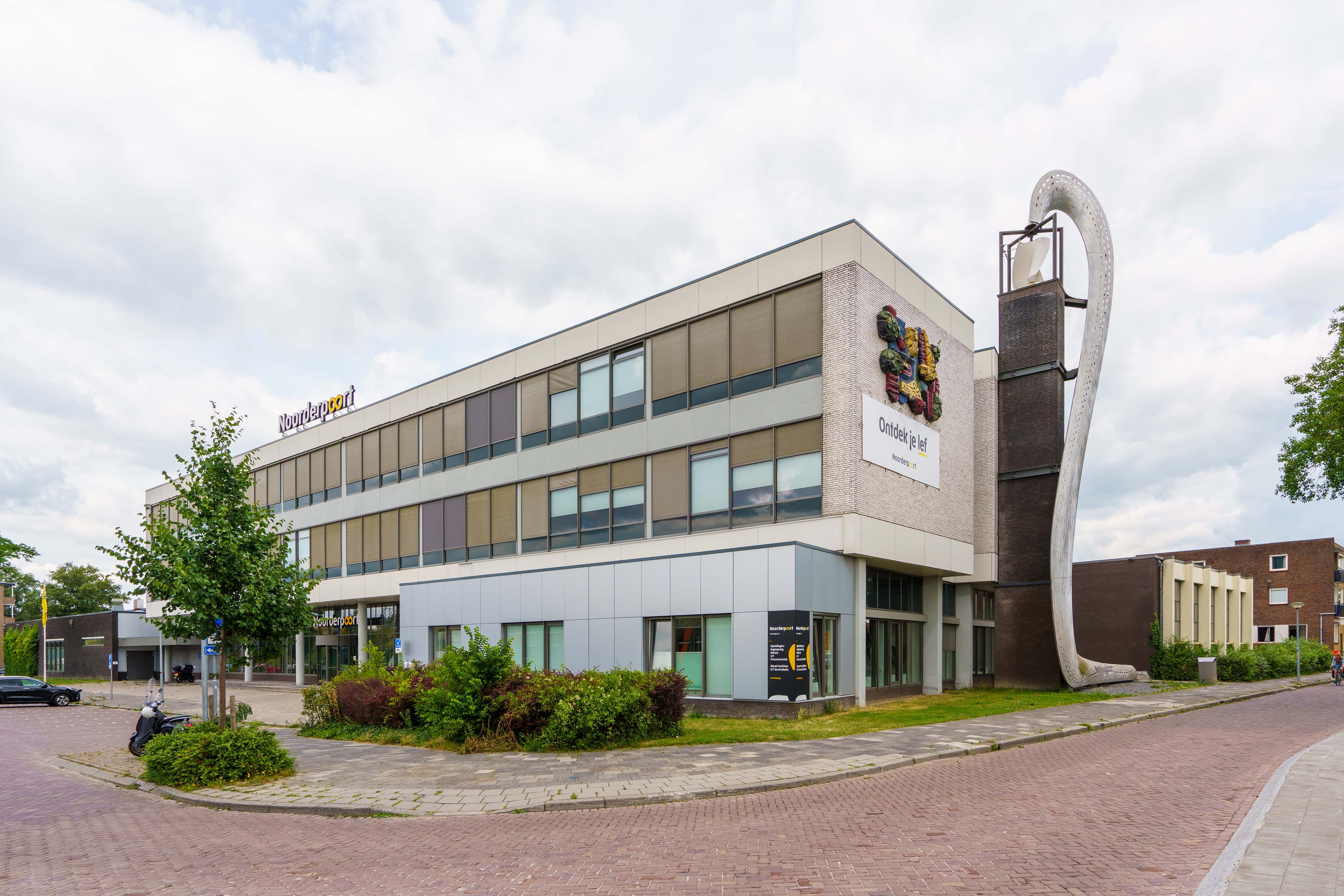 Gebouw van Noorderpoort locatie Muntinglaan 3 in Groningen met opvallende moderne gevel en herkenbaar kunstobject op de hoek