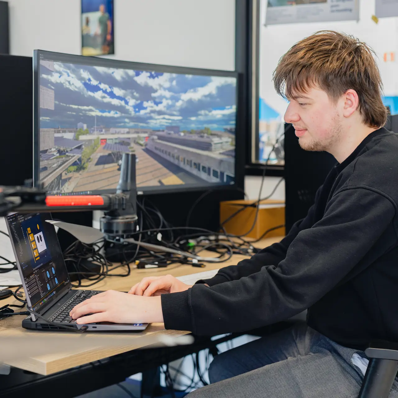 Student werkt met 3D-software op een computer, gericht op virtuele omgevingsontwikkeling.