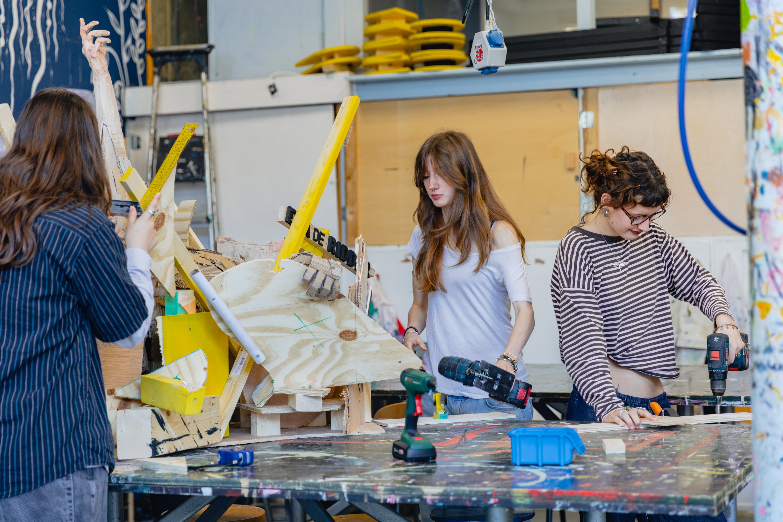 Studenten in werkplaats ontwerpen en bouwen ruimtelijke constructies met elektrische gereedschappen