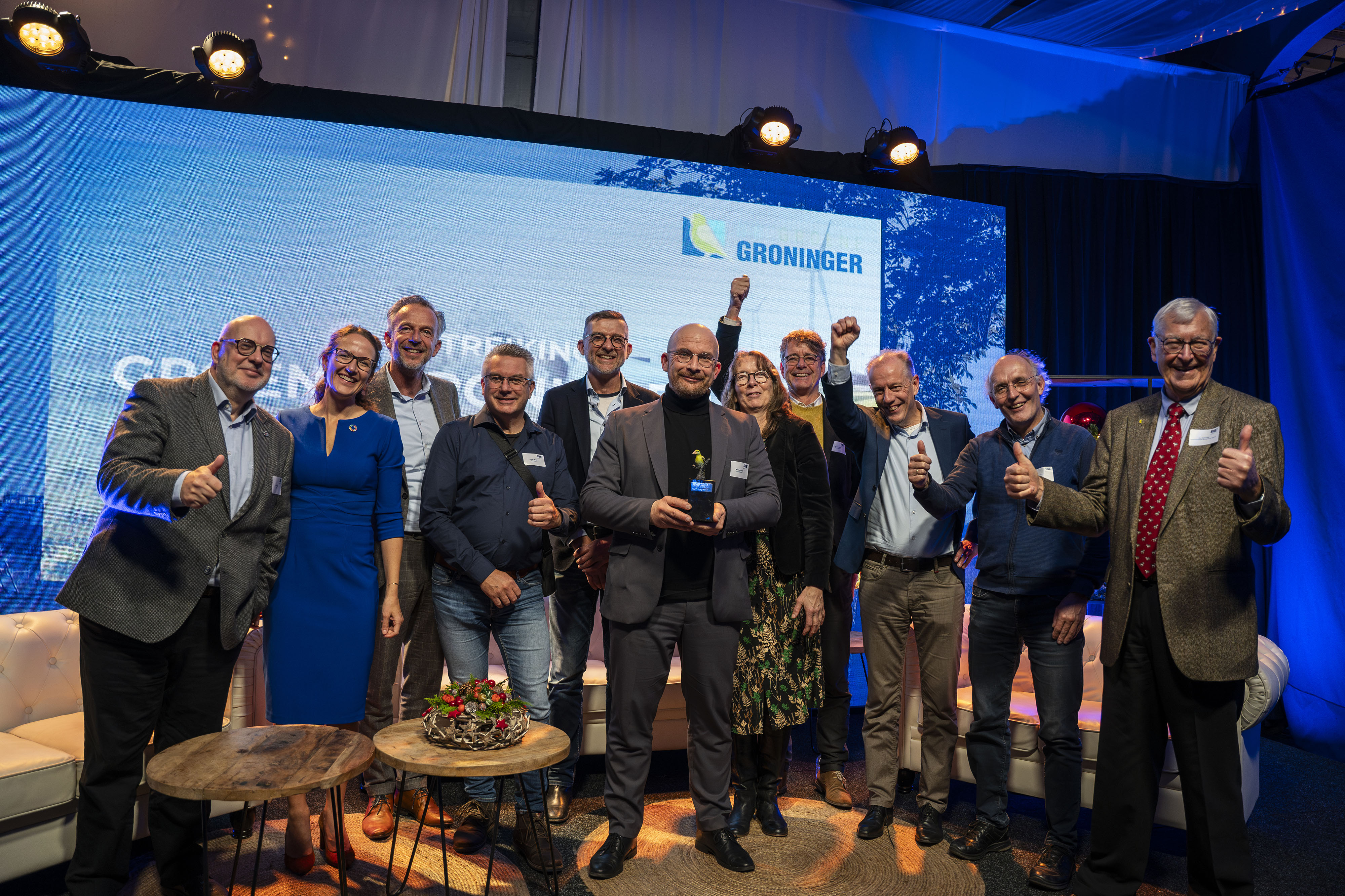 Groep professionals viert gezamenlijk de erkenning als Groene Groninger 2023 op een podium