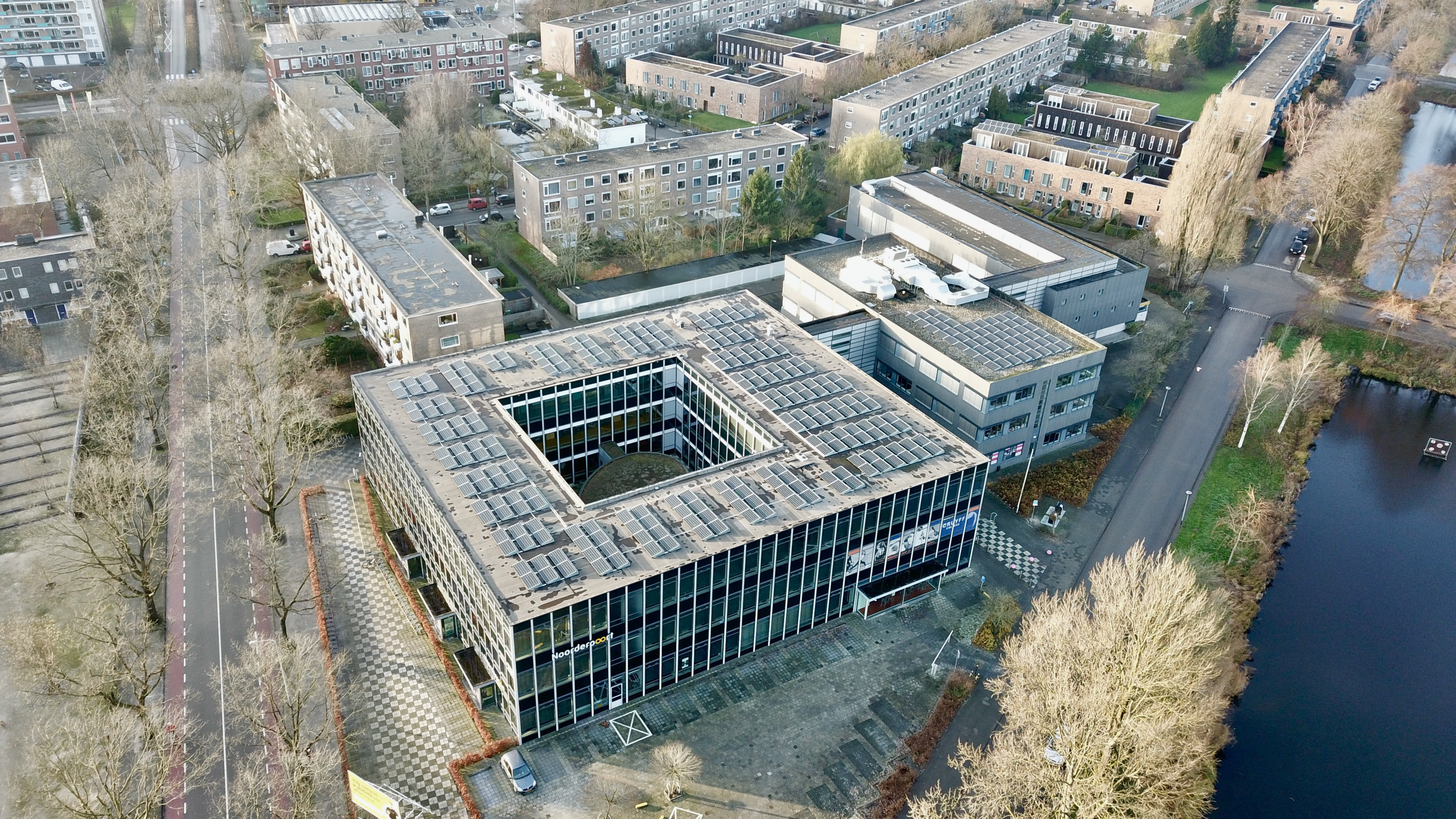 Luchtfoto van het Noorderpoort-onderwijsgebouw aan de Hora Siccamasingel in Groningen met omliggende woonwijken.