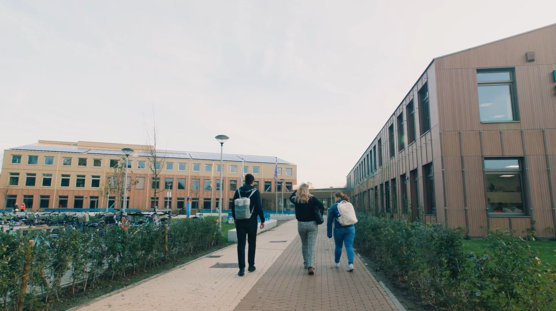 Studenten lopen over het pad tussen onderwijsgebouwen van Noorderpoort op Pastorielaan in Appingedam