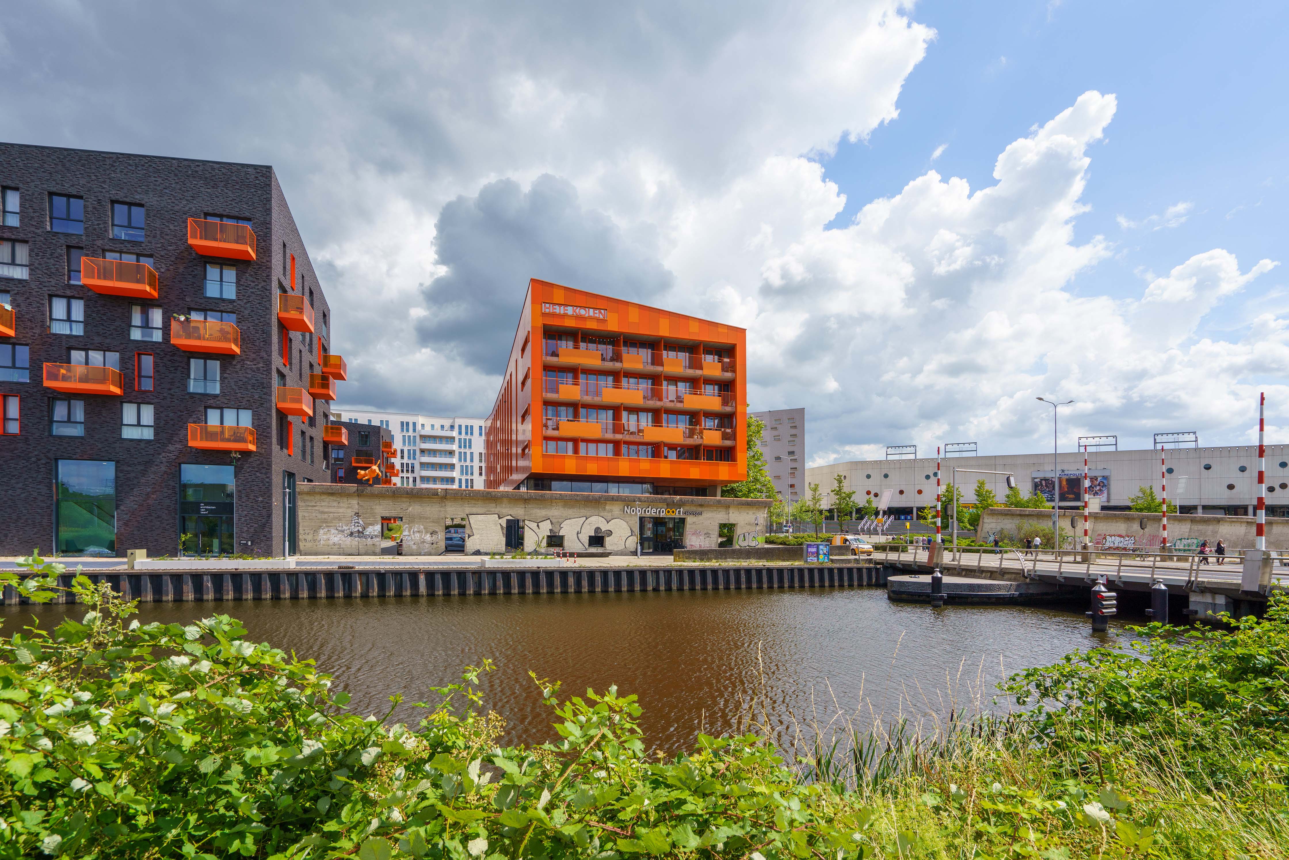 Moderne onderwijsgebouwen van Noorderpoort aan Boumaboulevard 400 in Groningen met waterpartij op de voorgrond