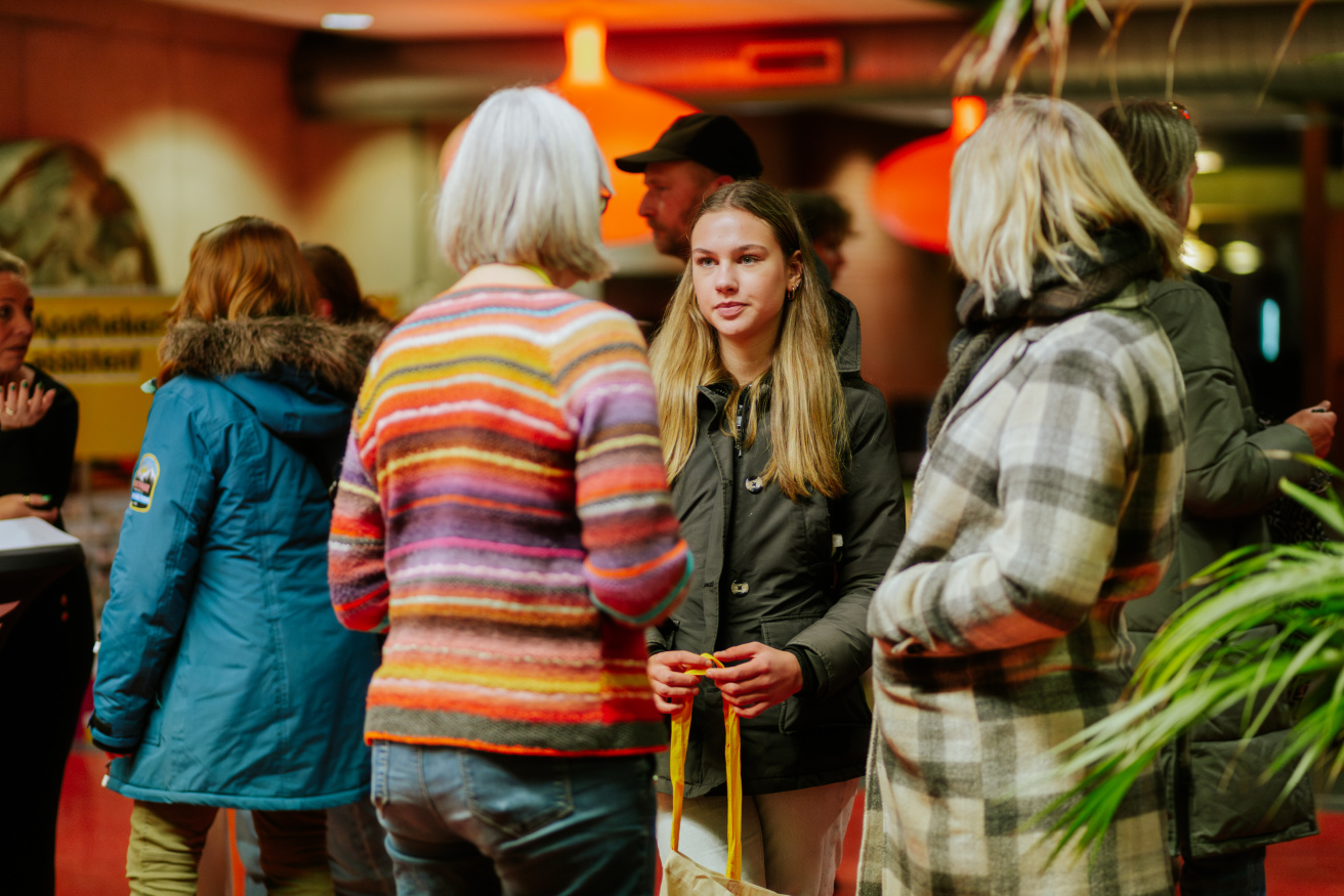 Bezoekers in gesprek tijdens een open dag van Noorderpoort, met toekomstige studenten en geïnteresseerden