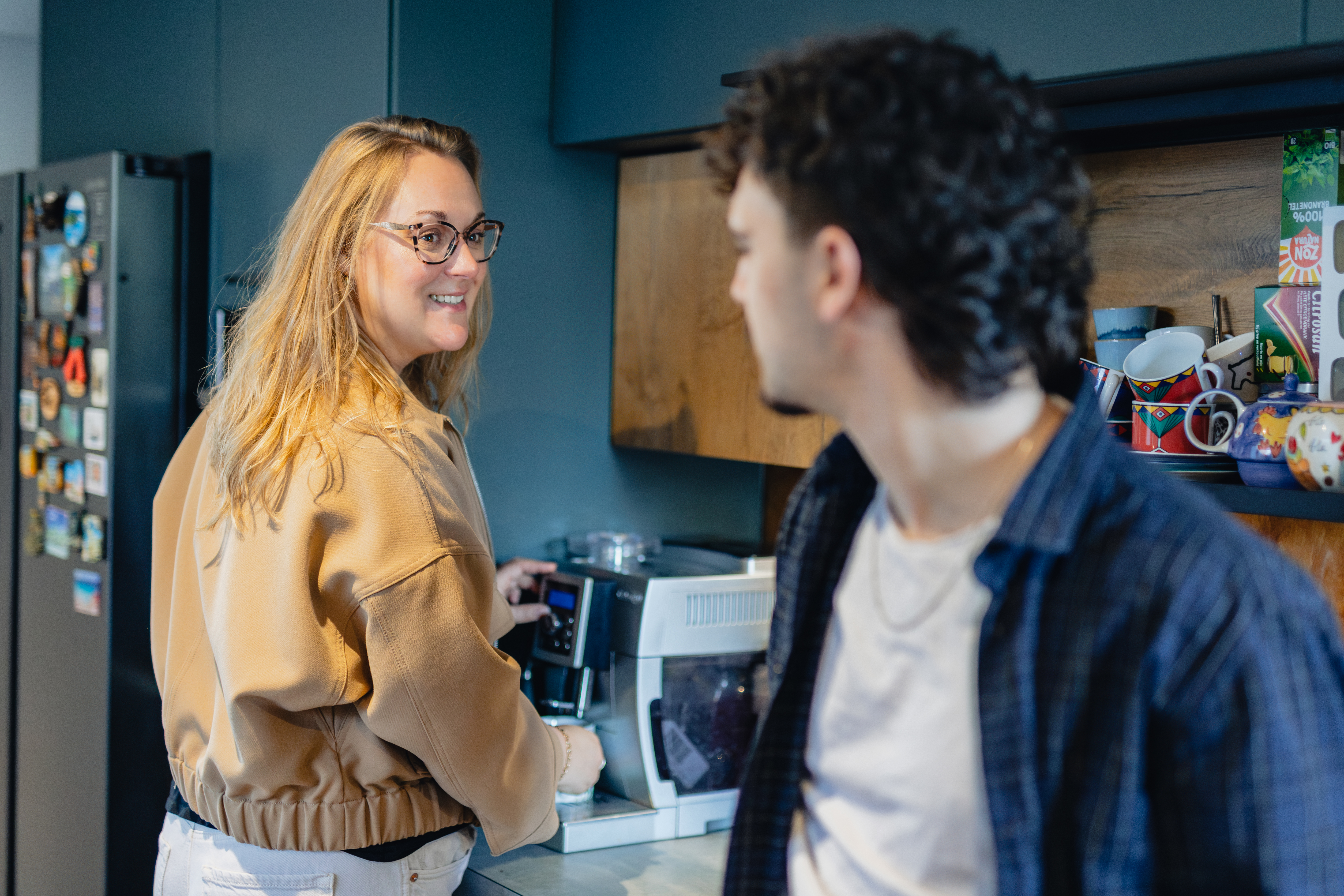 Twee personen in gesprek tijdens een studiekeuzemoment in een informele keukenruimte.
