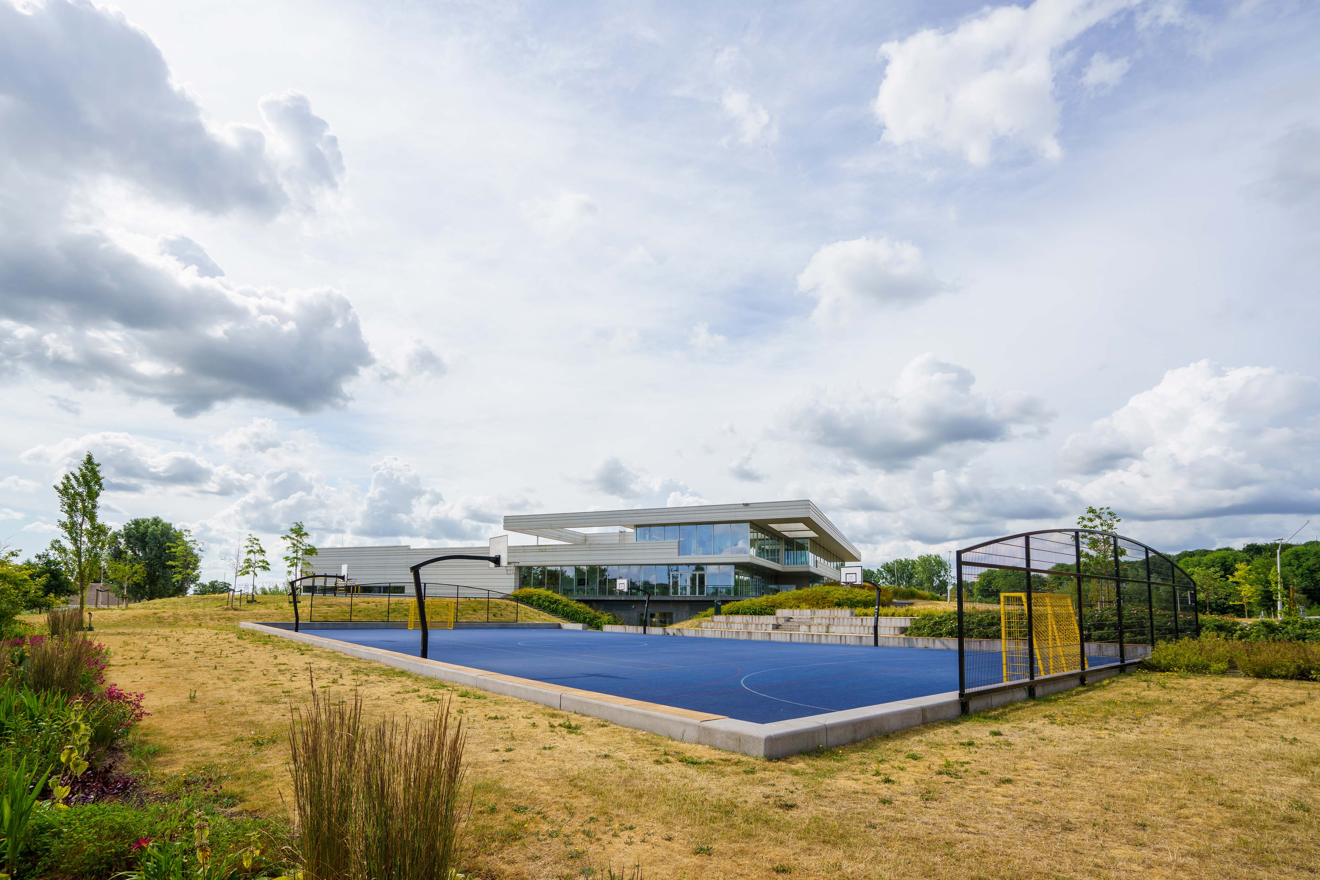 Moderne onderwijsvoorziening aan Helperpark 306 met sportveld in een groene omgeving in Groningen.