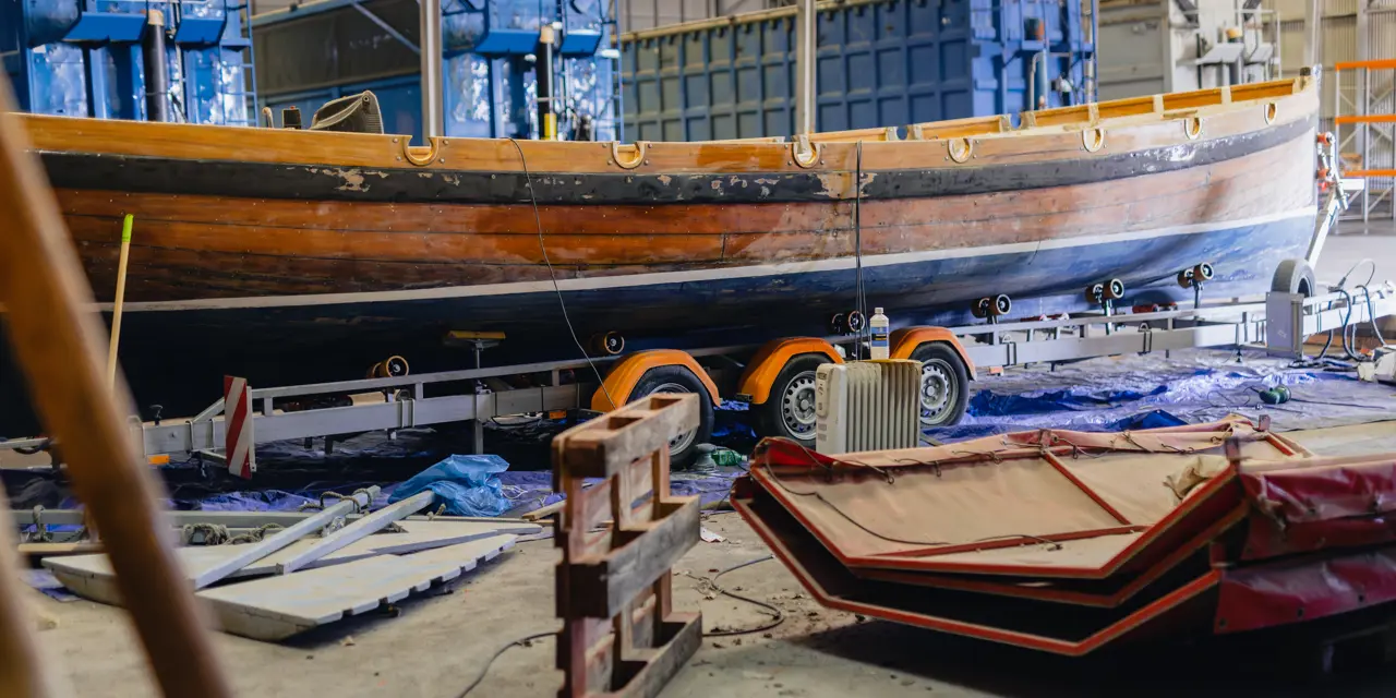 Houten zeilboot De Zeeolifant in een werkhal, onderdeel van een maritiem project voor studenten