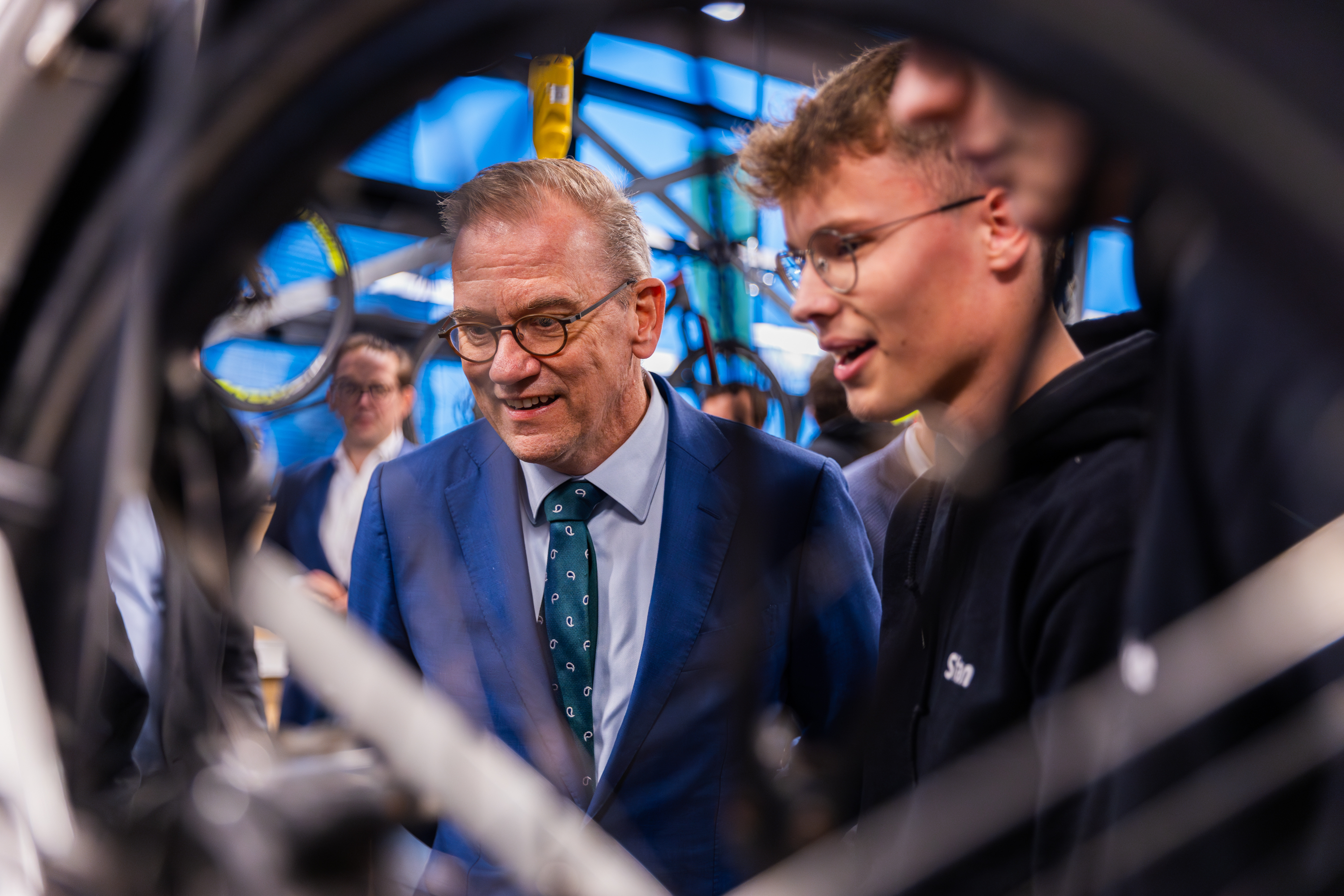 Student legt technische aspecten van elektrische mobiliteit uit aan bezoeker in leeromgeving