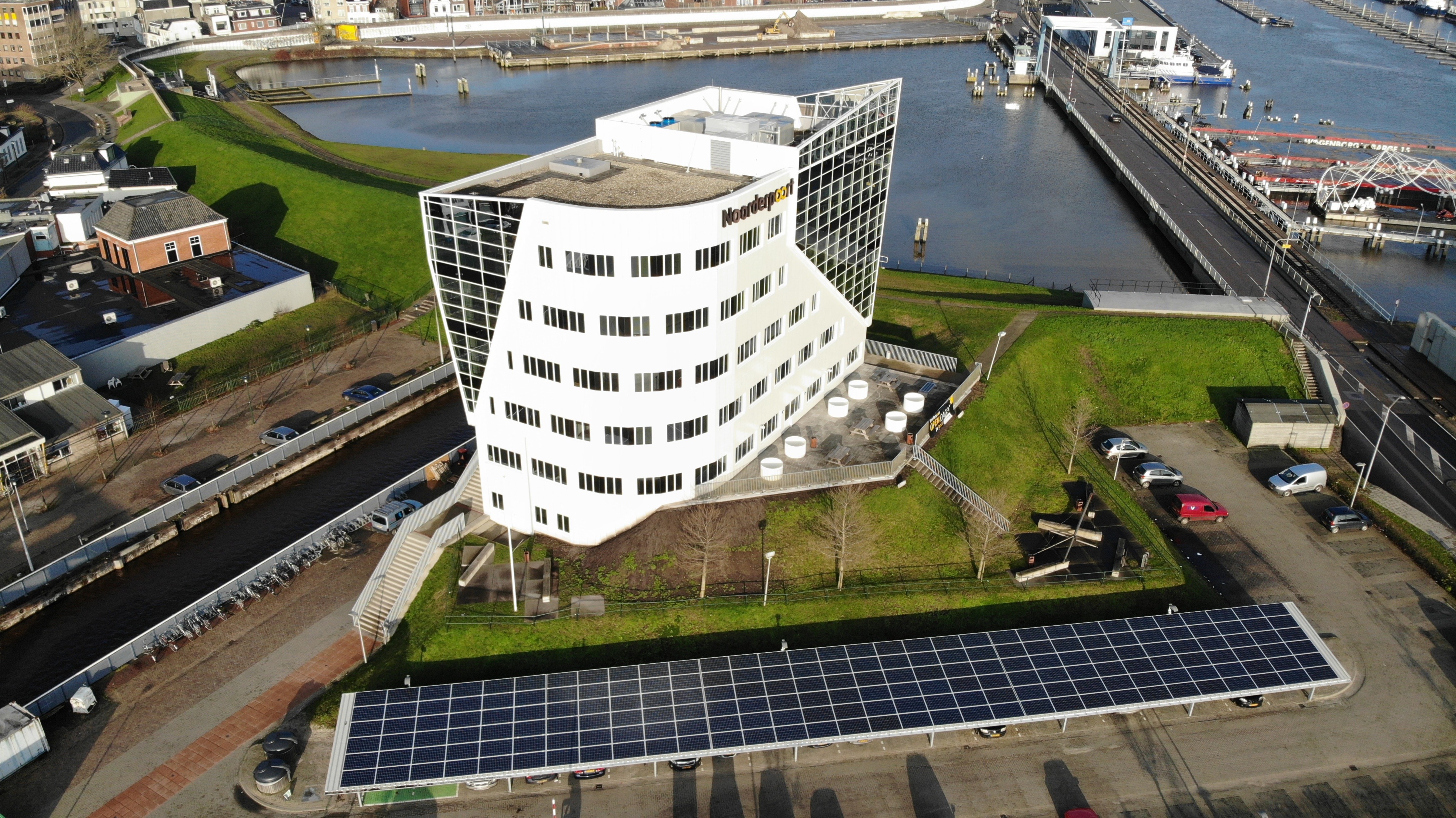 Hoofdgebouw van Noorderpoort Duurswoldlaan in Delfzijl met water en loopbrug in de omgeving