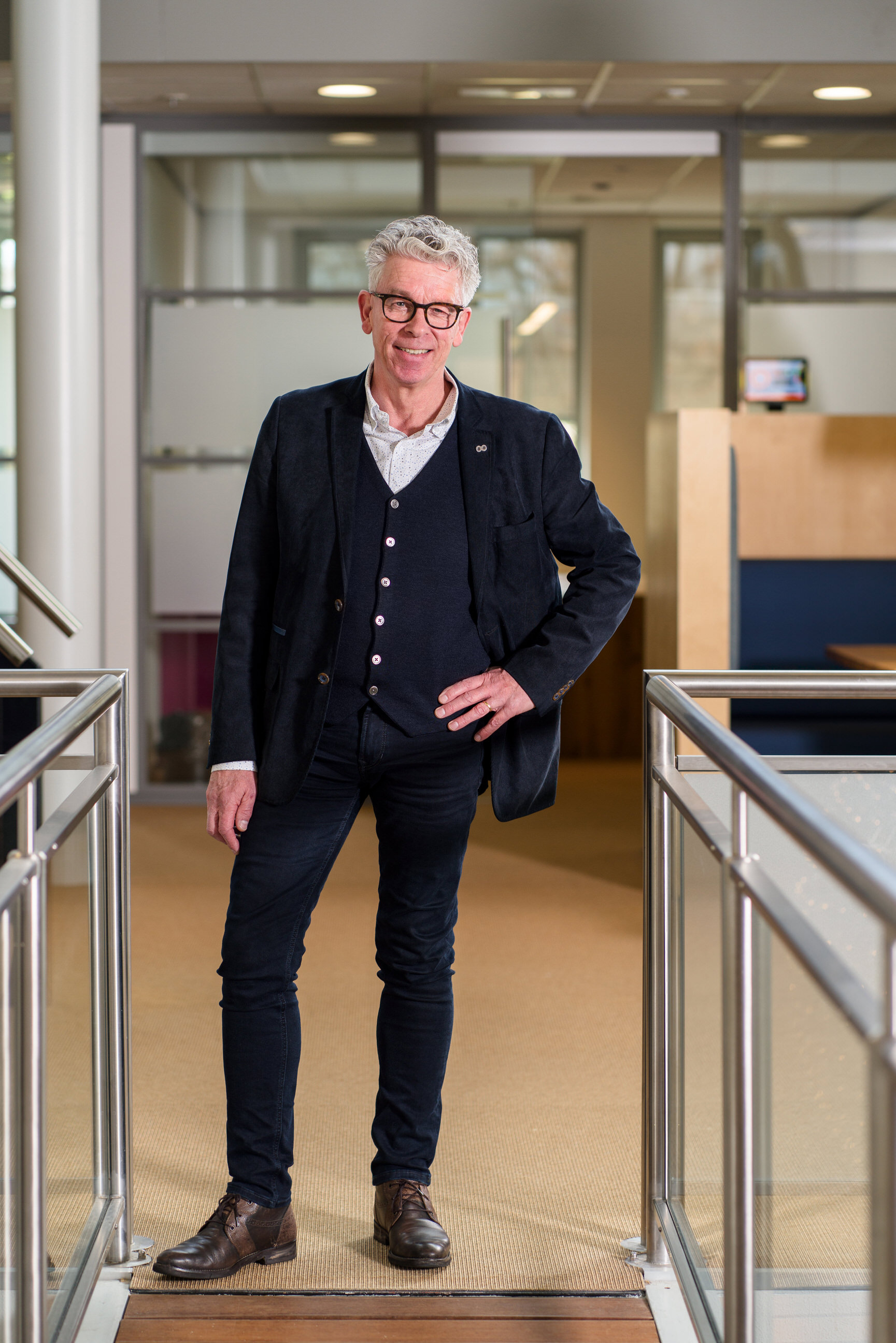 Persoon staat in werkruimte, mogelijk betrokken bij practoraten binnen onderwijsorganisatie Noorderpoort