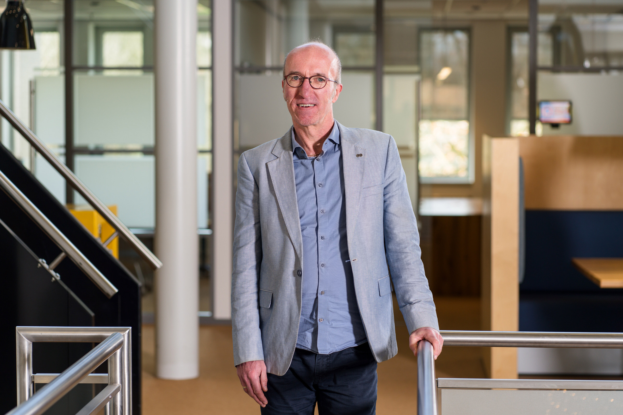 Medewerker in zakelijke kleding staat in een moderne onderwijsomgeving van Noorderpoort.