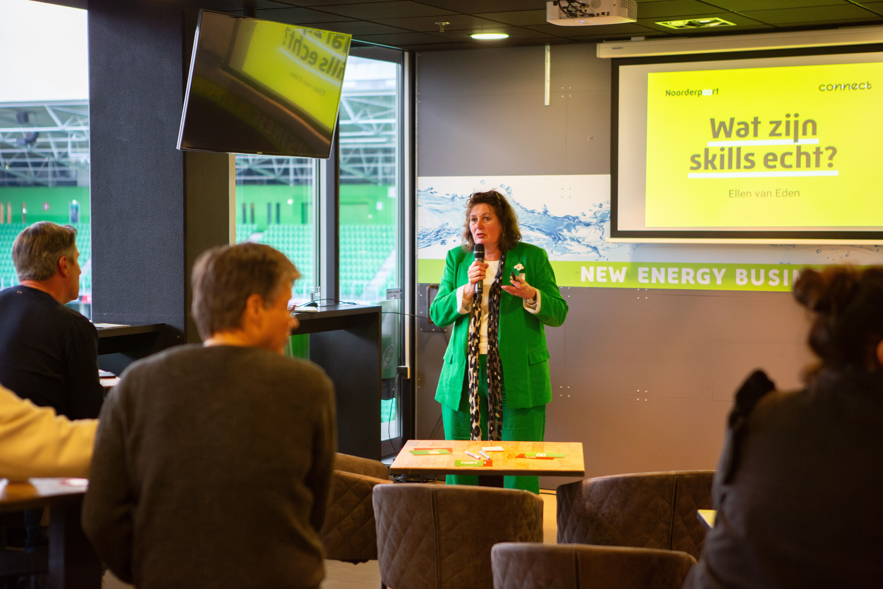 Spreker presenteert over skillsgericht leren aan toehoorders tijdens een bijeenkomst over onderwijsvernieuwing.