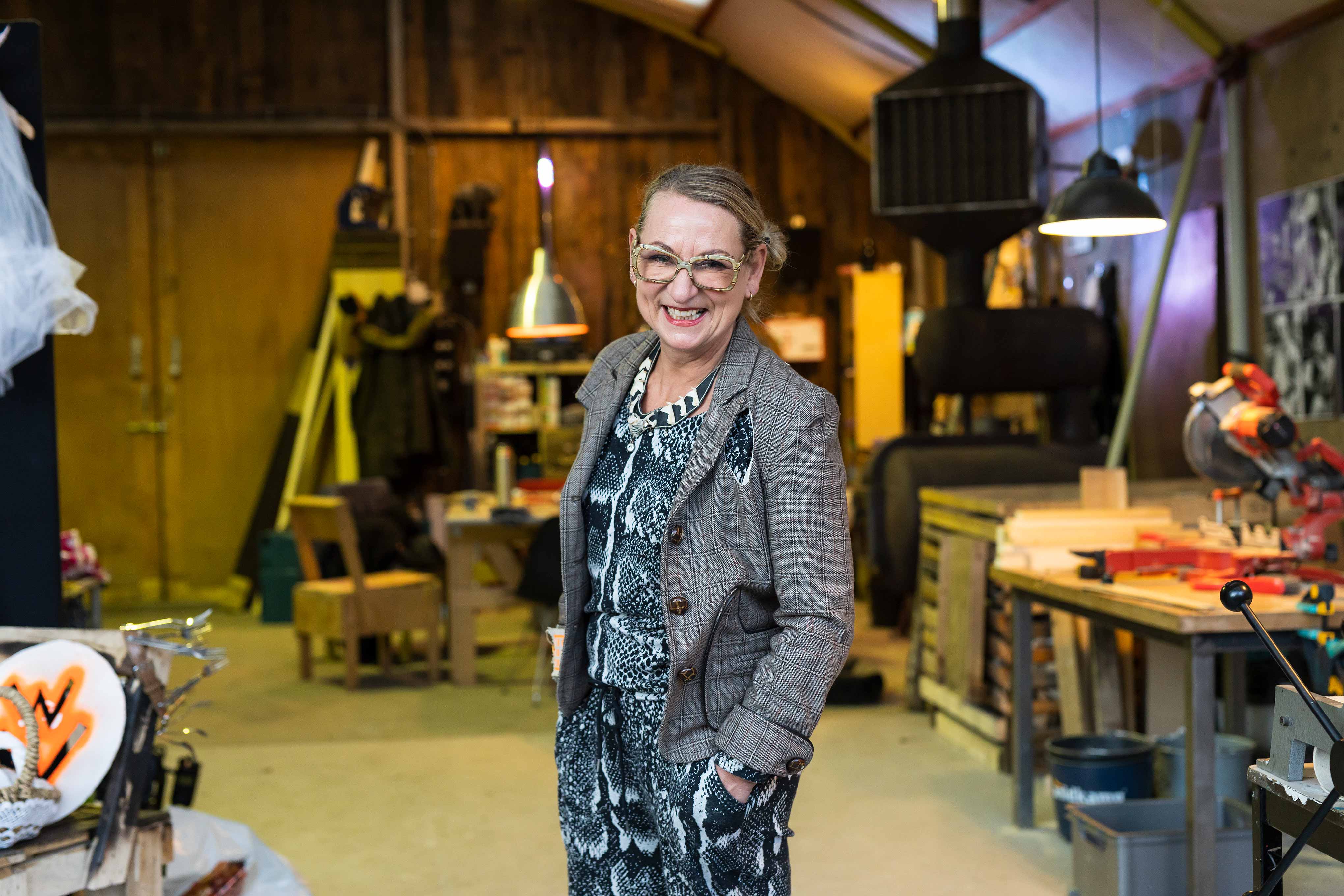 Docent in een werkplaats die creativiteit en duurzaamheid combineert met enthousiasme en vakmanschap.