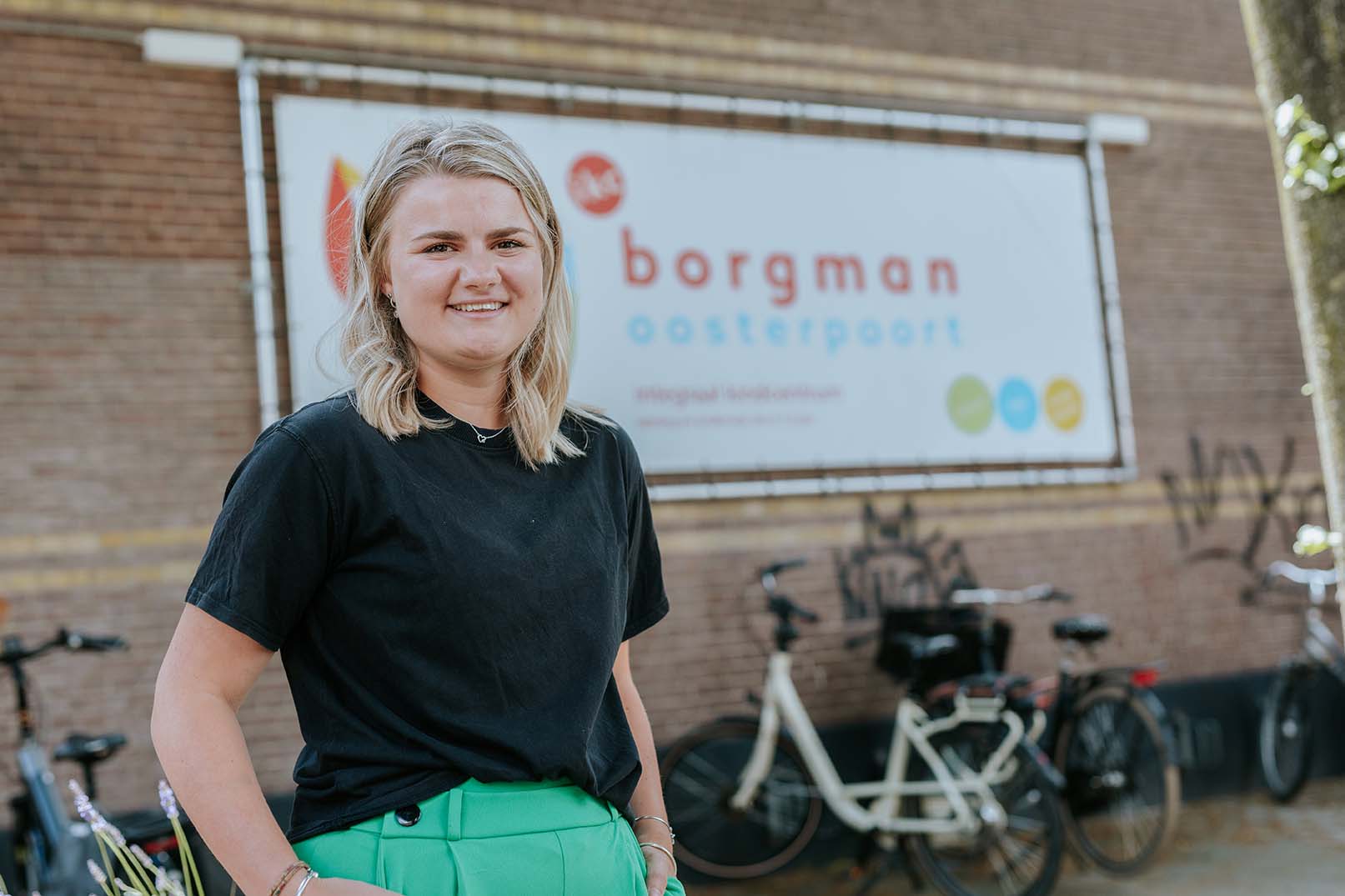 Een onderwijsassistent staat buiten school Borgman Noorderpoort, waar zij verschillende onderwijsbanen verkent.
