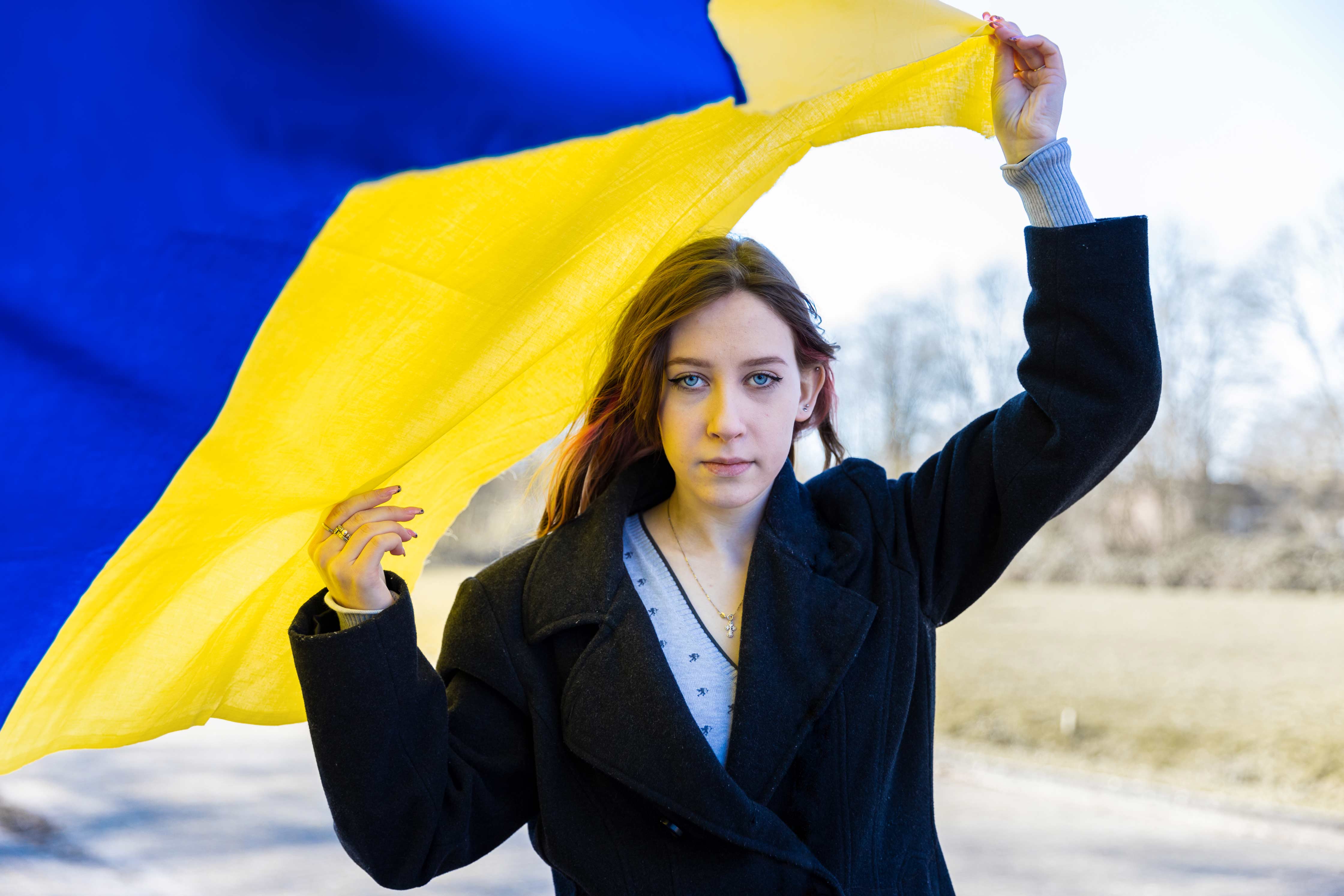 Student houdt Oekraïense vlag vast ter ondersteuning en reflectie op toekomstmogelijkheden in Oekraïne.