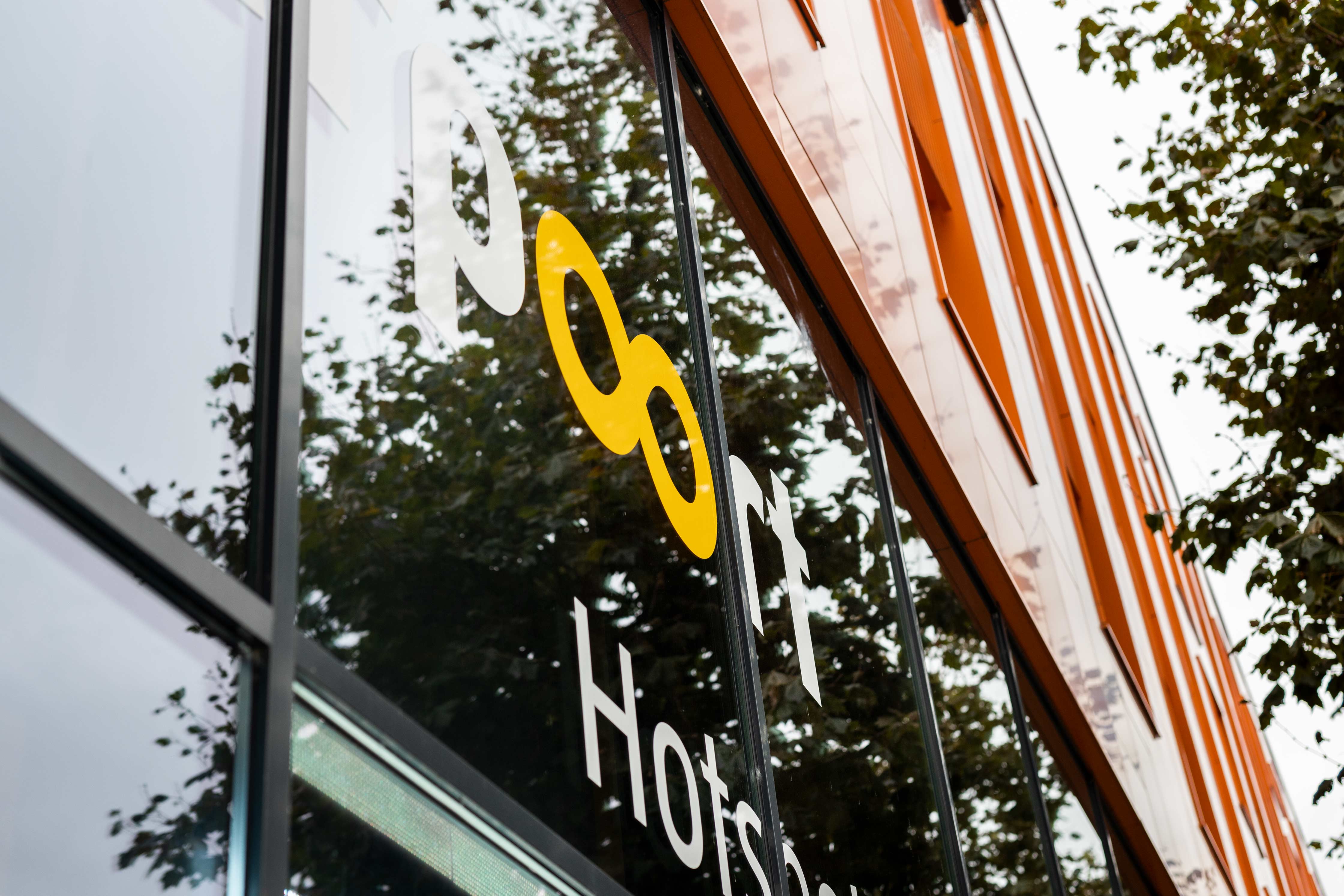 De gevel van het Noorderpoort hoofdkantoor met een herkenbaar geel logo en glazen ramen.