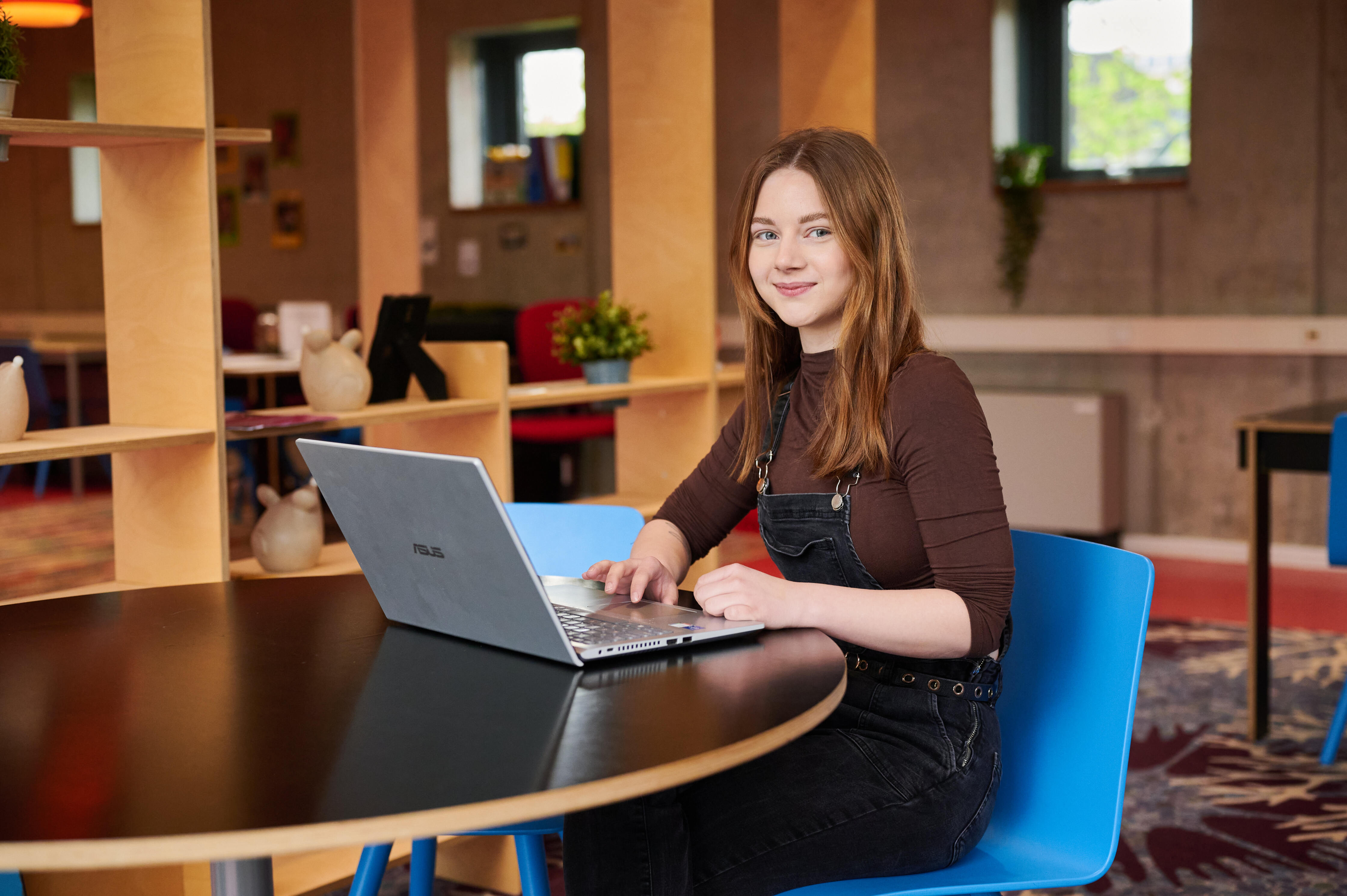 Toekomstige student werkt aan laptop aan tafel in leeromgeving van Noorderpoort