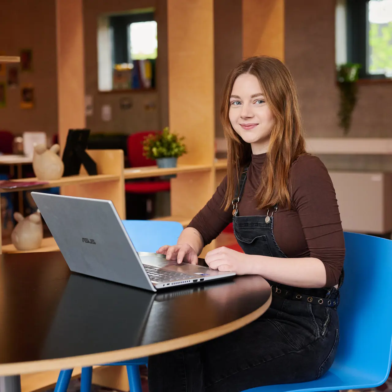 Toekomstige student werkt aan laptop aan tafel in leeromgeving van Noorderpoort