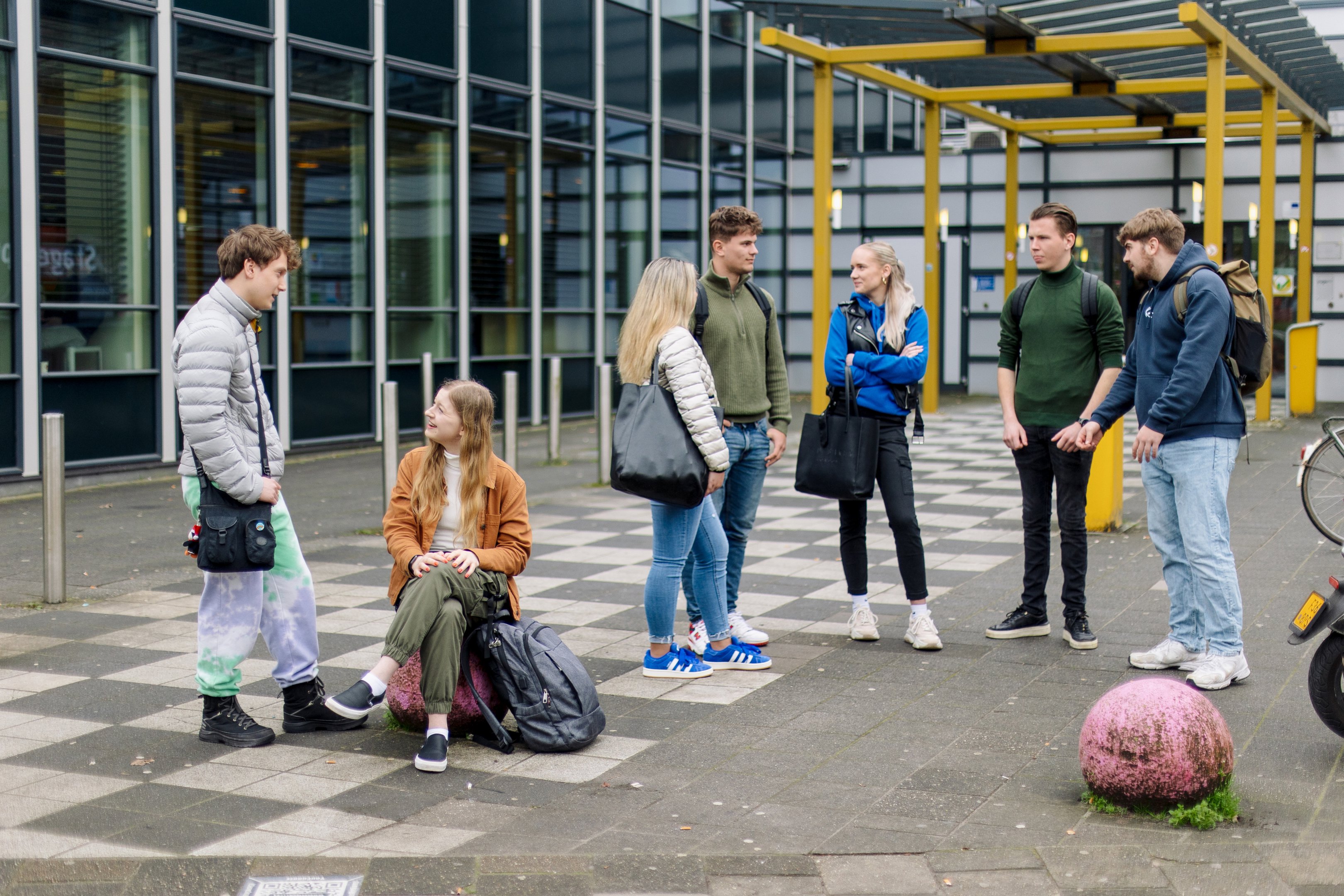 Studenten in gesprek op het schoolplein, overleg over toelating en studieopties bij Noorderpoort.