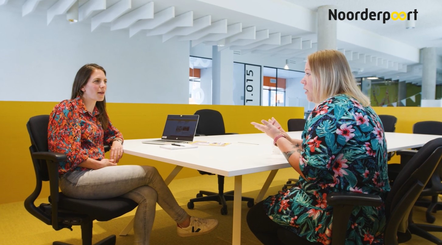 Twee mensen voeren een studieadviesgesprek bij Noorderpoort om passende mbo-opleiding te bespreken.