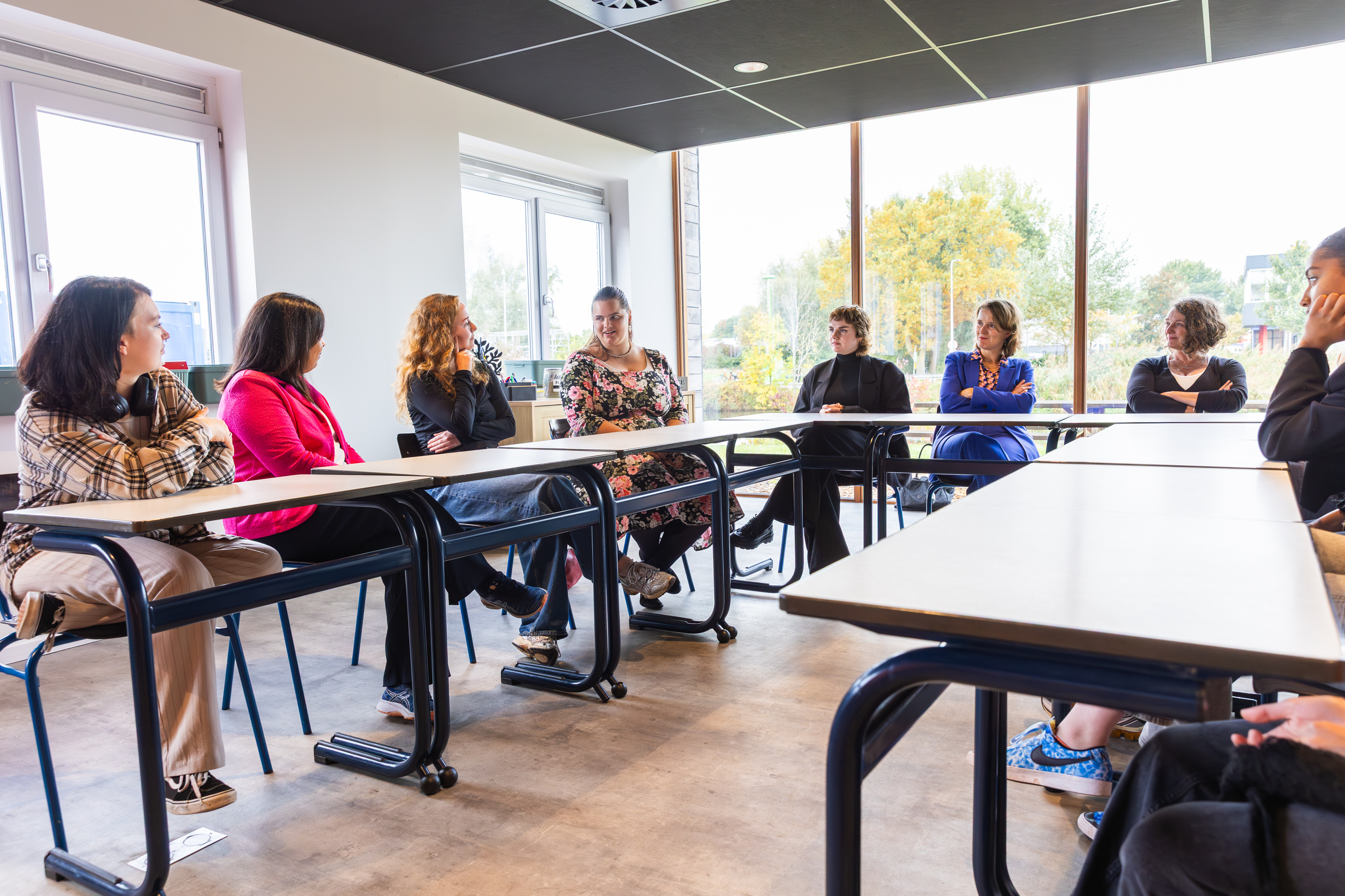 Groep jongeren en begeleiders in overleg tijdens een bijeenkomst over ondersteuning van kwetsbare studenten