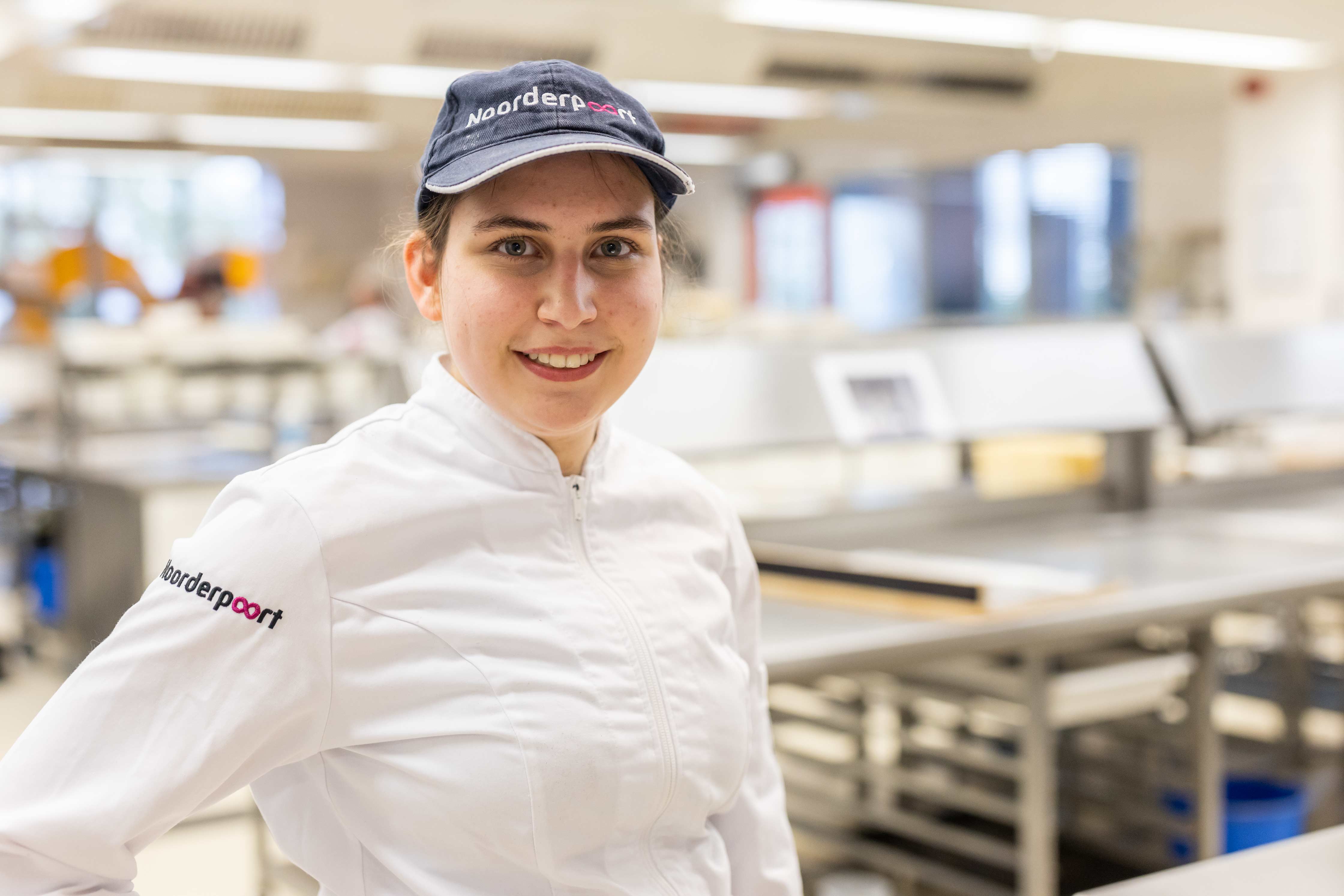 MBO-student in keukenuniform actief in een professionele bakkerijomgeving van Noorderpoort