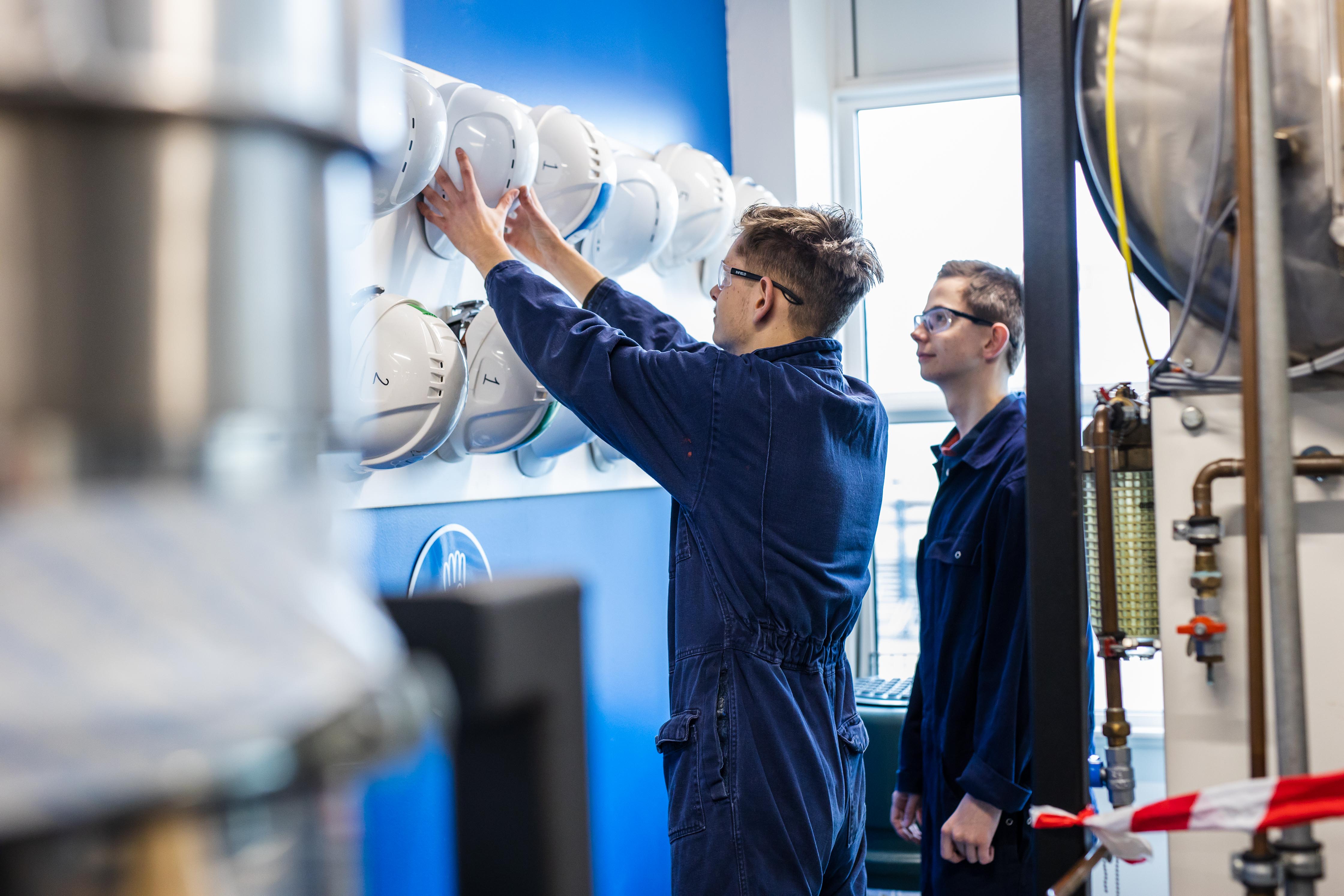 Technische studenten aan het werk met procesapparatuur in een opleidingslaboratorium