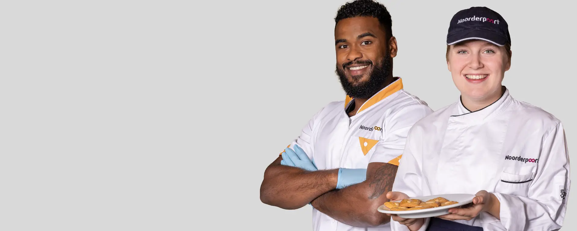 Twee studenten in beroepskleding presenteren versgebakken producten met trots.