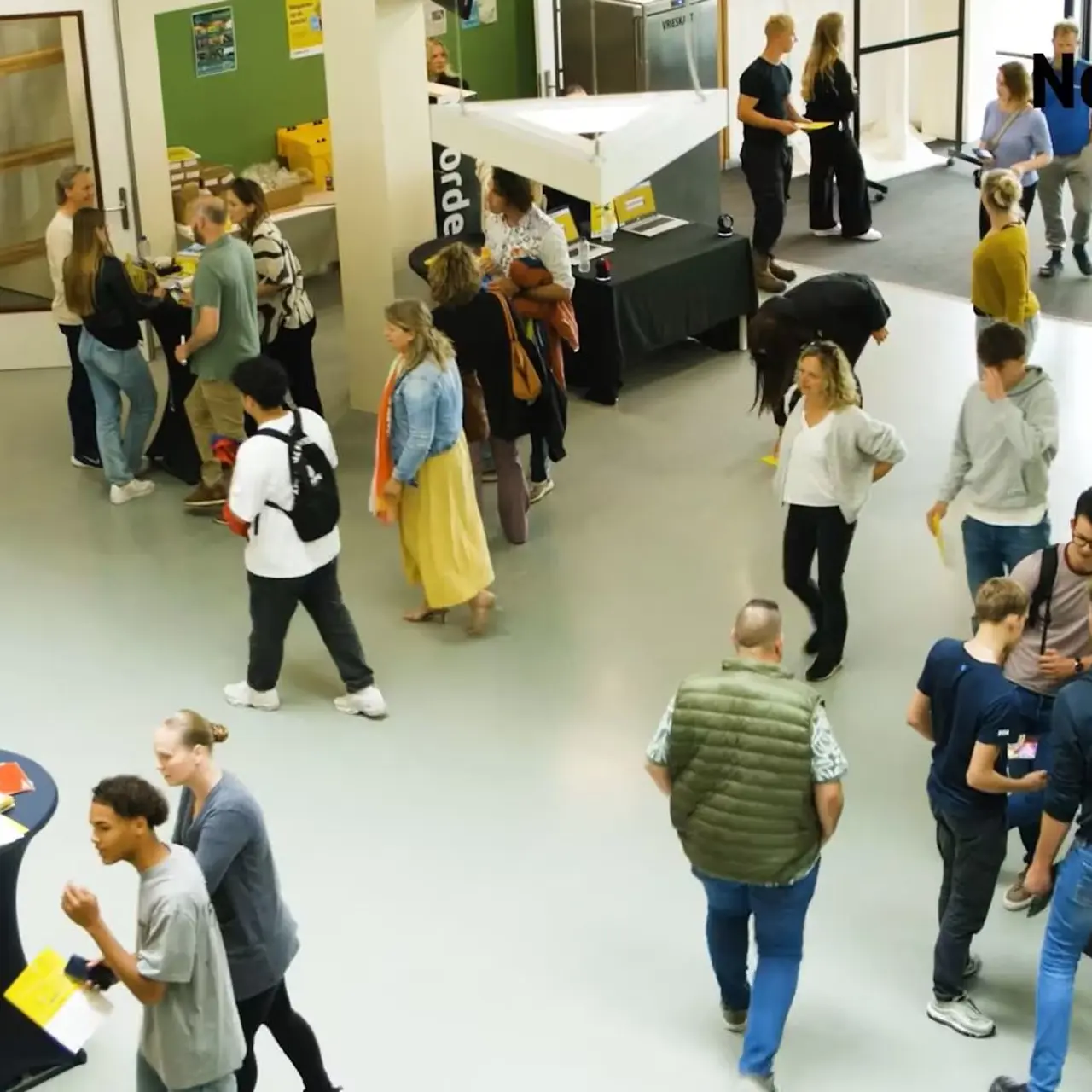 Bezoekers en toekomstige studenten verkennen informatiestands tijdens een evenement van Noorderpoort.