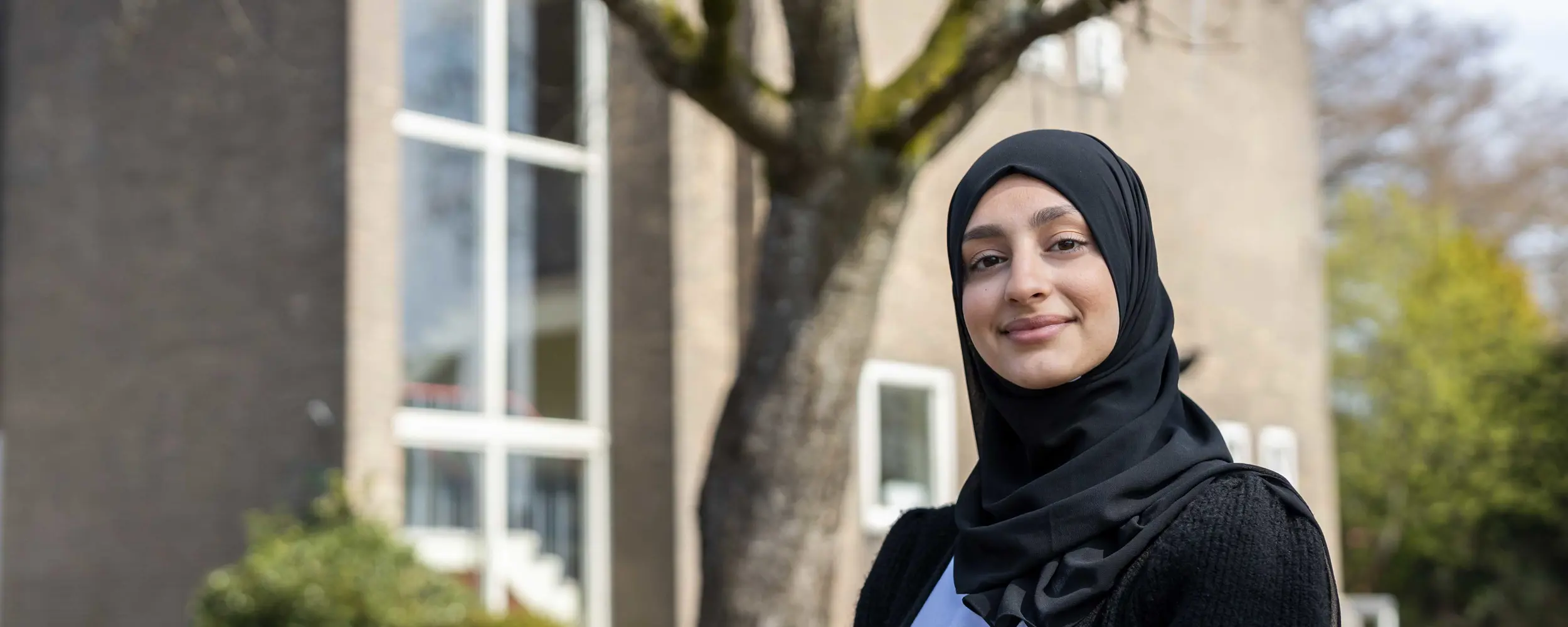 Student van Noorderpoort buiten op de campus tijdens de ramadan, met een vriendelijk en zelfverzekerd houding.