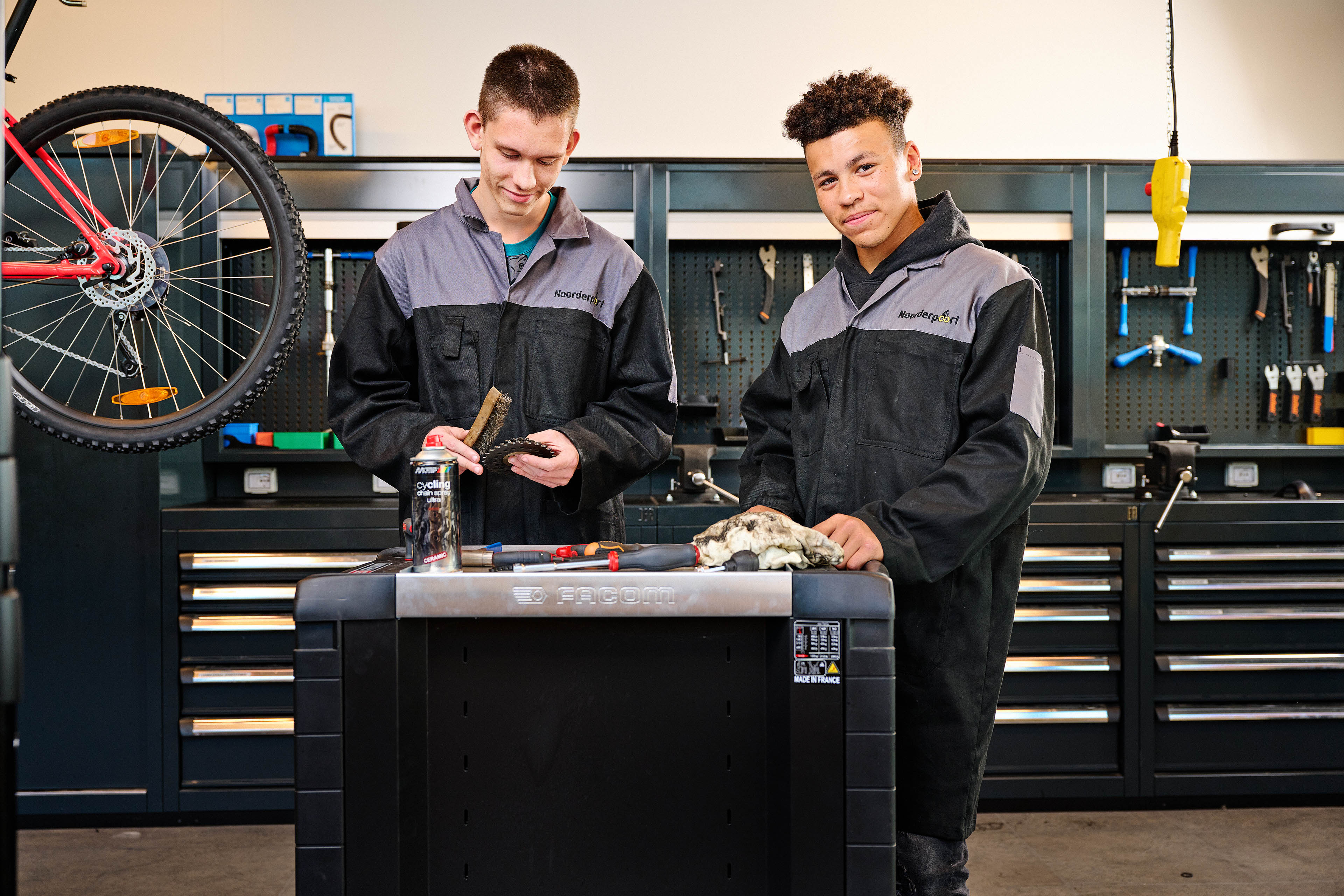 Twee studenten oefenen technisch vakmanschap bij een werkbank in een leerwerkplaats
