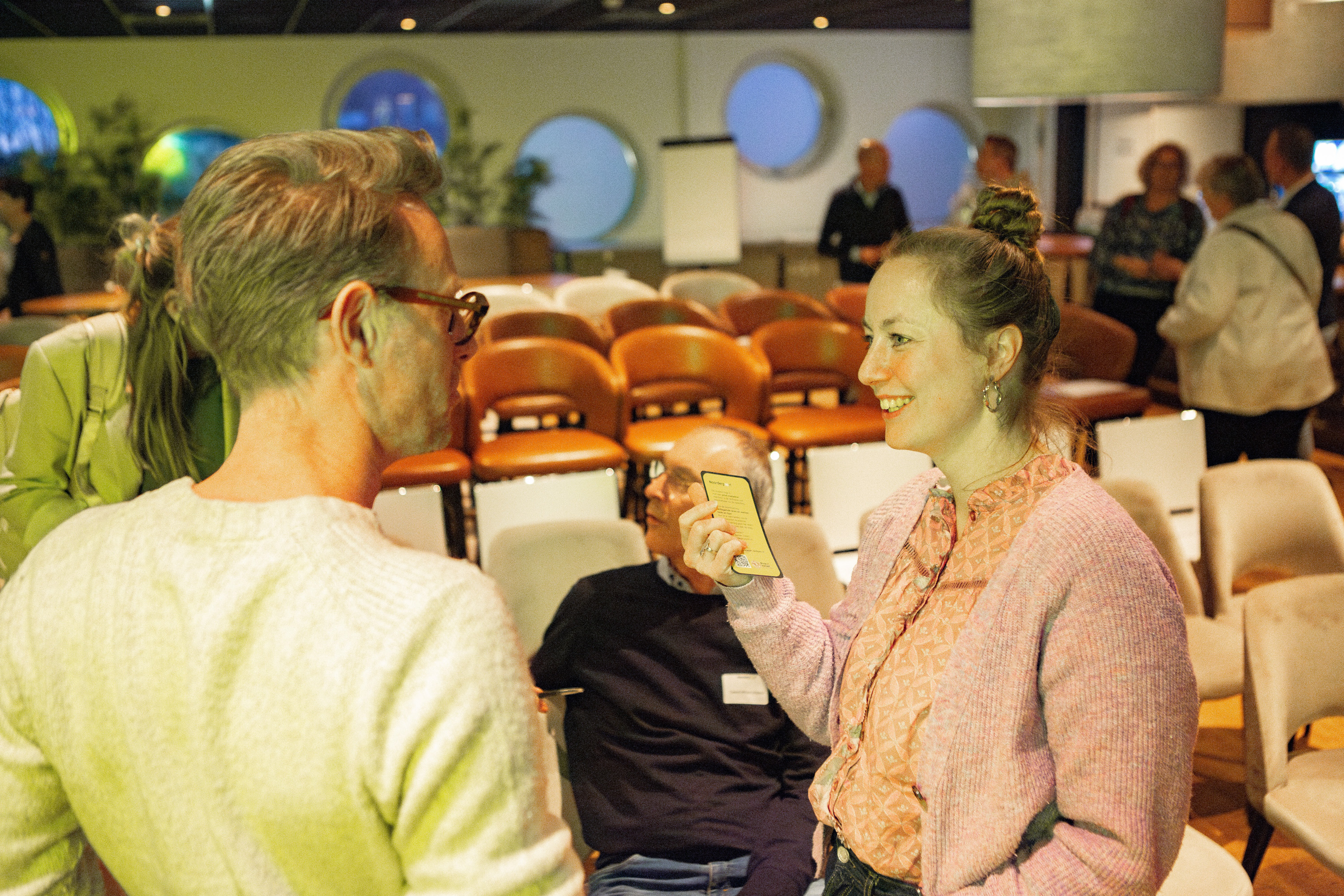 Studenten en docent voeren een gesprek over vaardigheden in een onderwijsomgeving met stoelen op de achtergrond