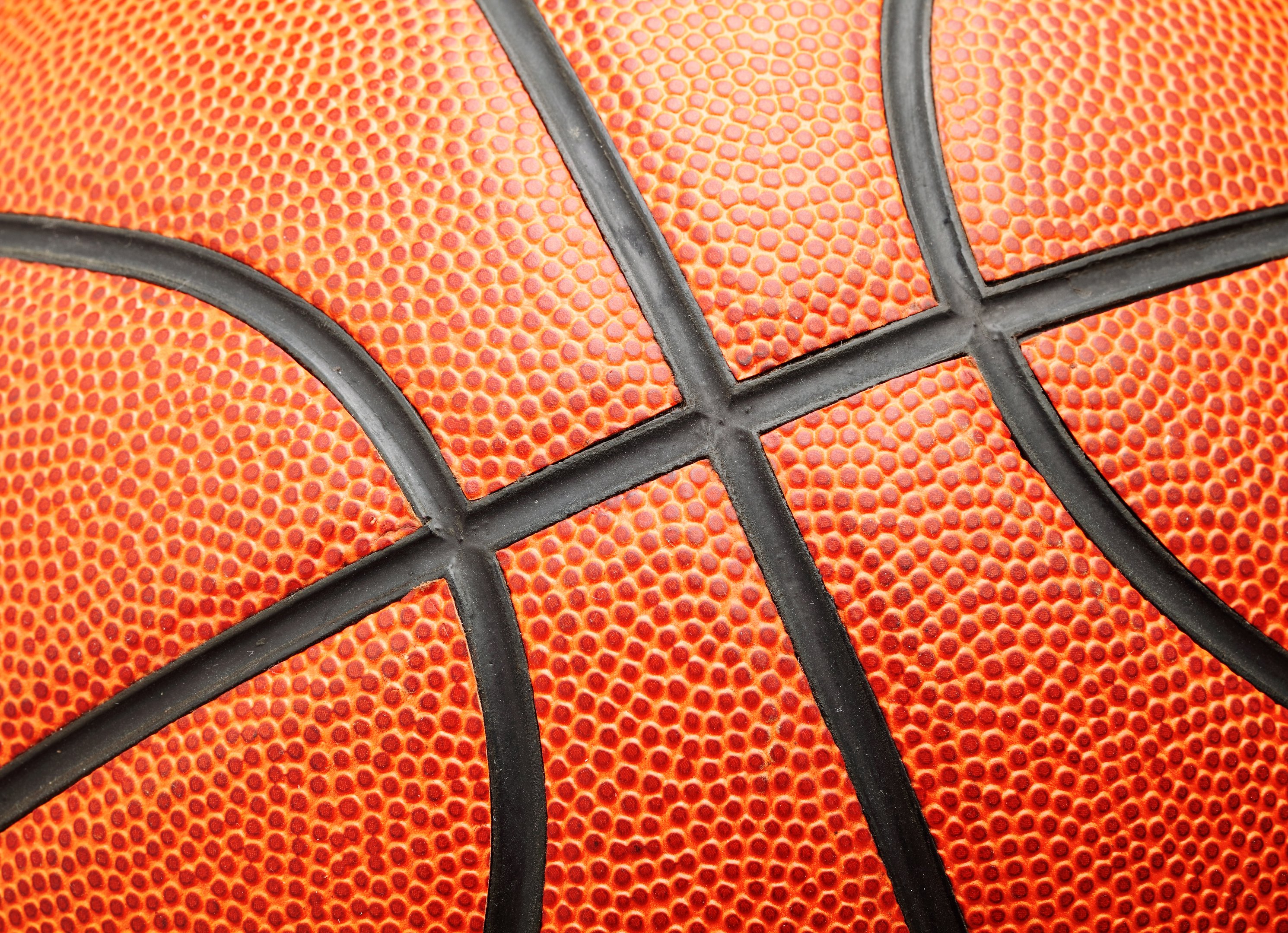 Close-up van het oppervlak en patroon van een basketbal, symbool voor sportieve samenwerking