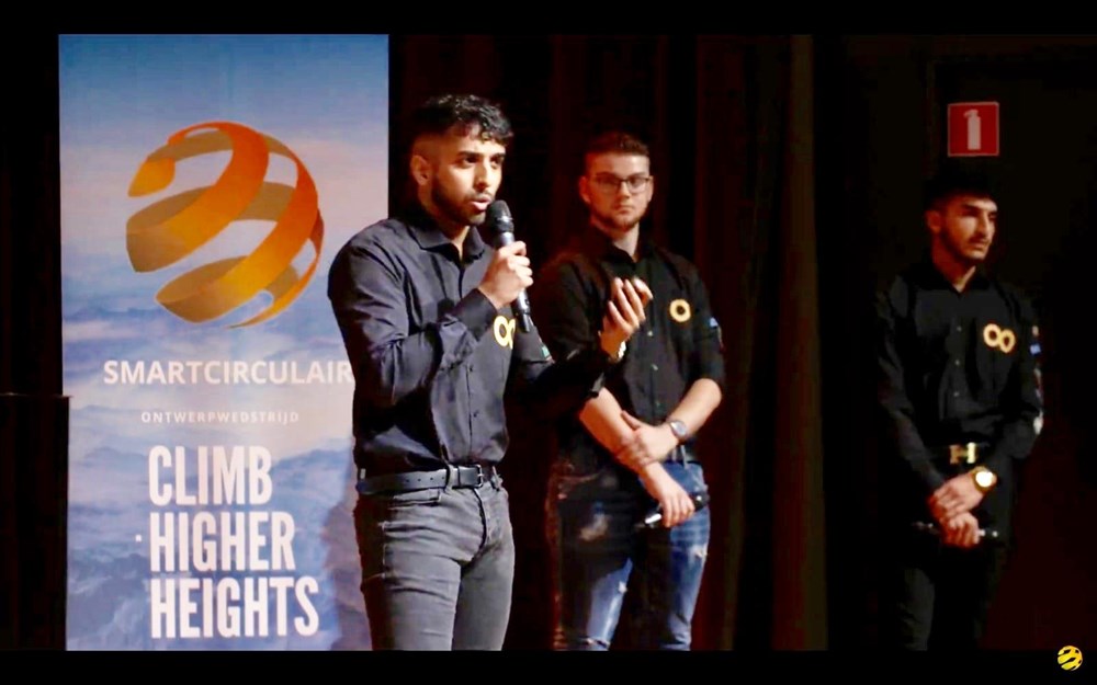 Student presenteert voorbereidend project tijdens SMARTCirculair challenge in podiumomgeving met twee medestudenten