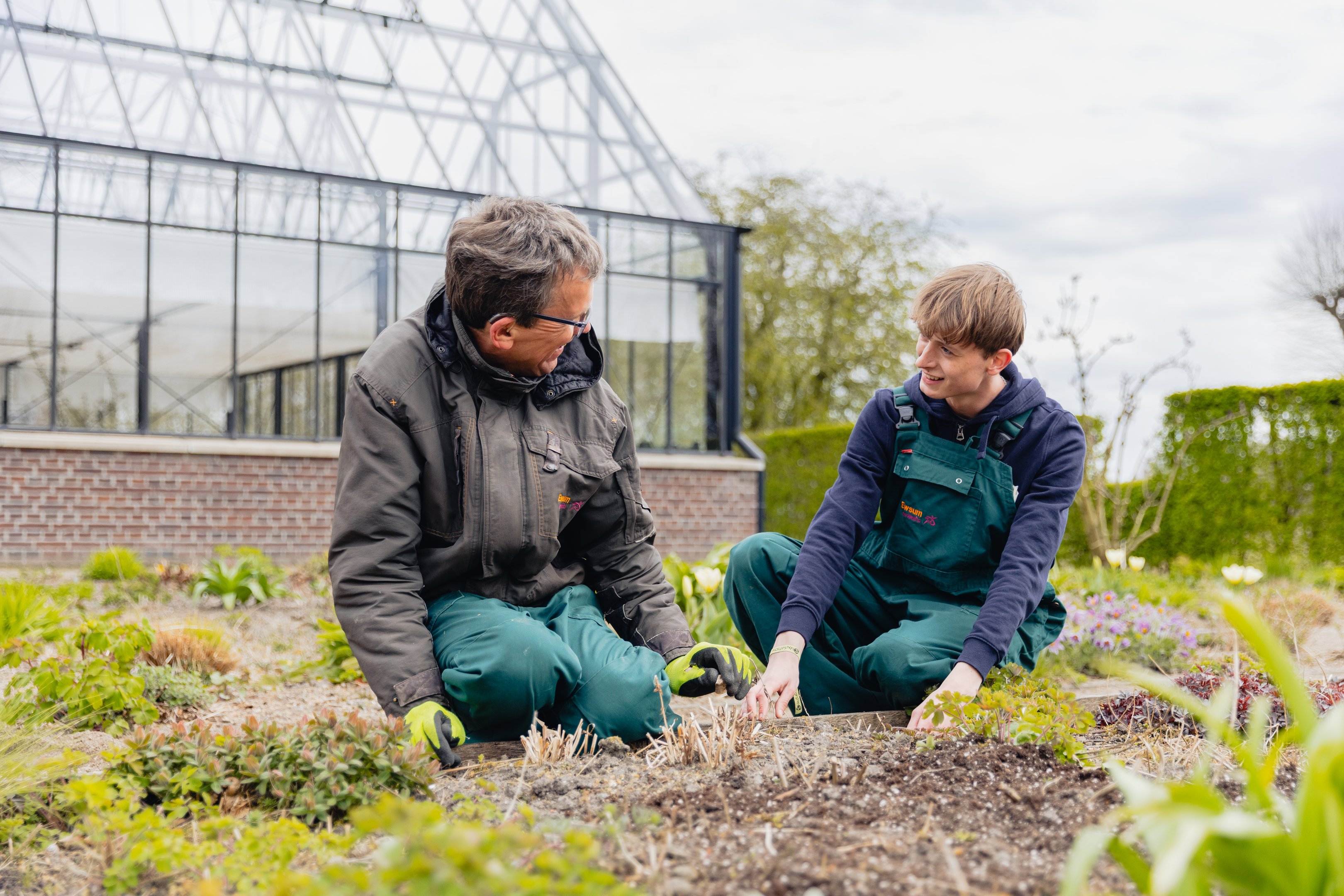 Twee mbo-studenten voeren samen buiten tuinwerkzaamheden uit bij kwekerij WerkPro Op Ewsum.
