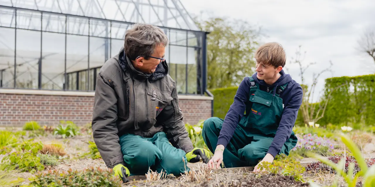 Twee mbo-studenten voeren samen buiten tuinwerkzaamheden uit bij kwekerij WerkPro Op Ewsum.