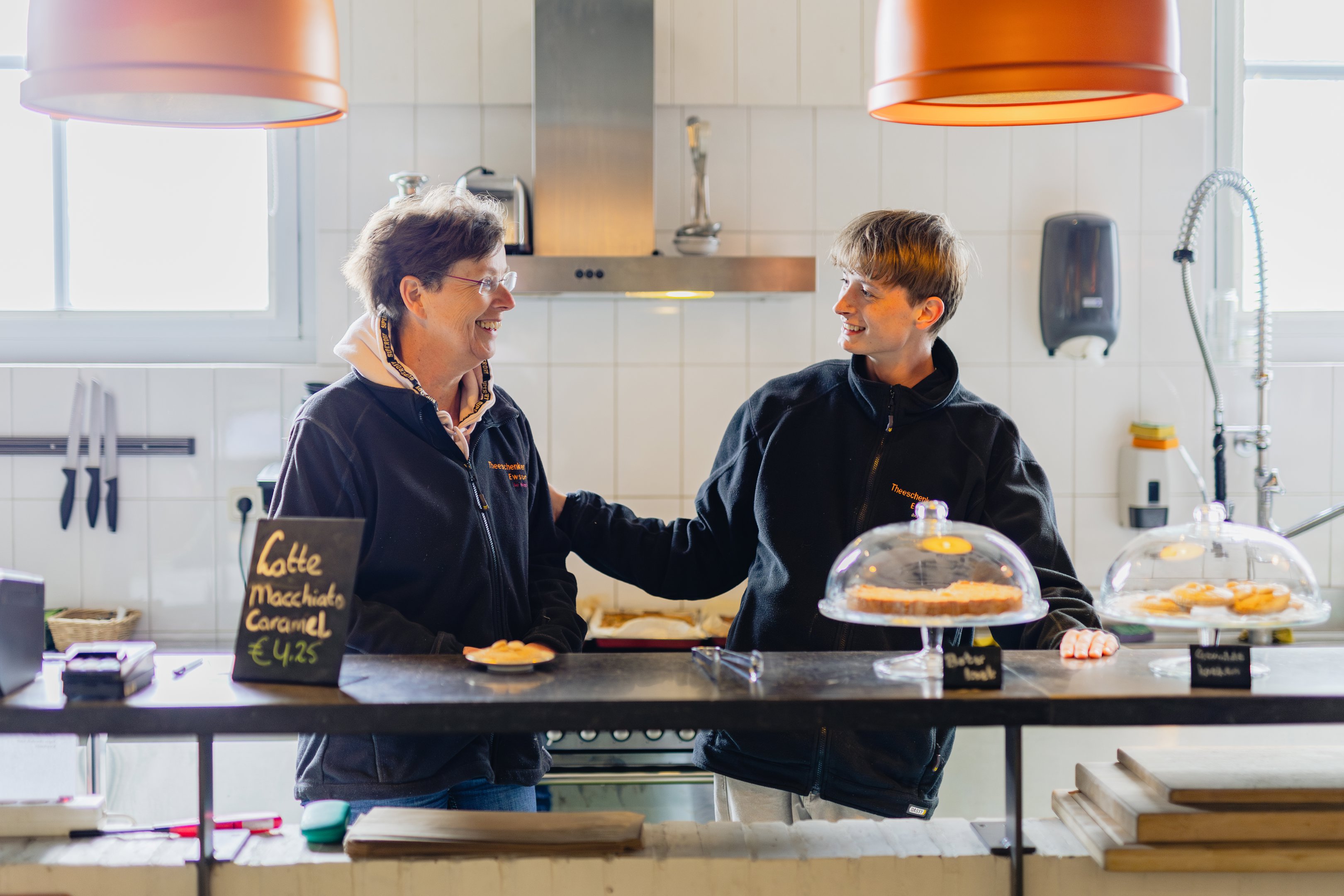 Begeleider maatschappelijke zorg praat met stagiair tijdens werkdag bij WerkPro in horecagelegenheid.