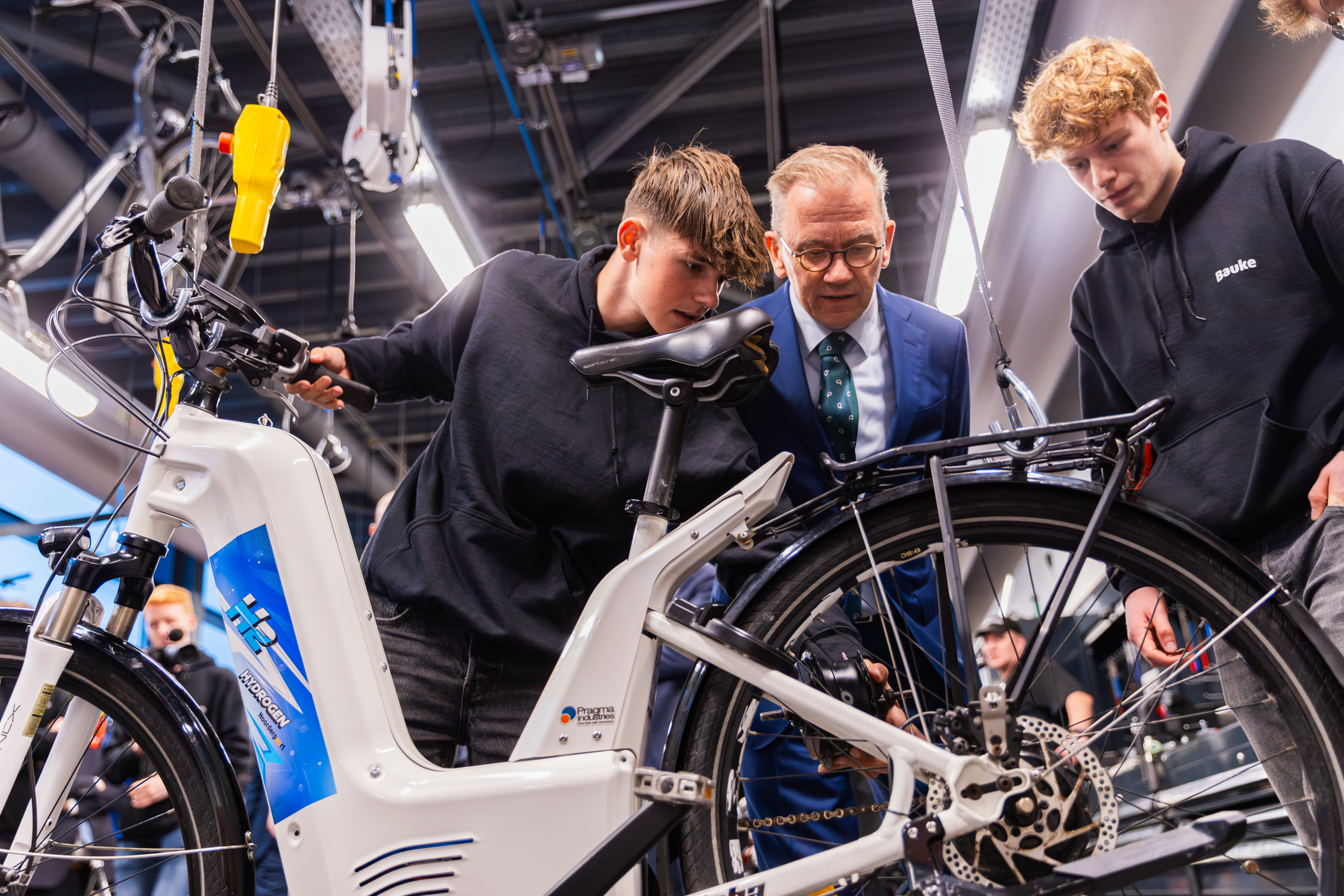 Studenten werken aan een elektrische fiets tijdens een praktijkles over duurzame mobiliteit bij Noorderpoort.