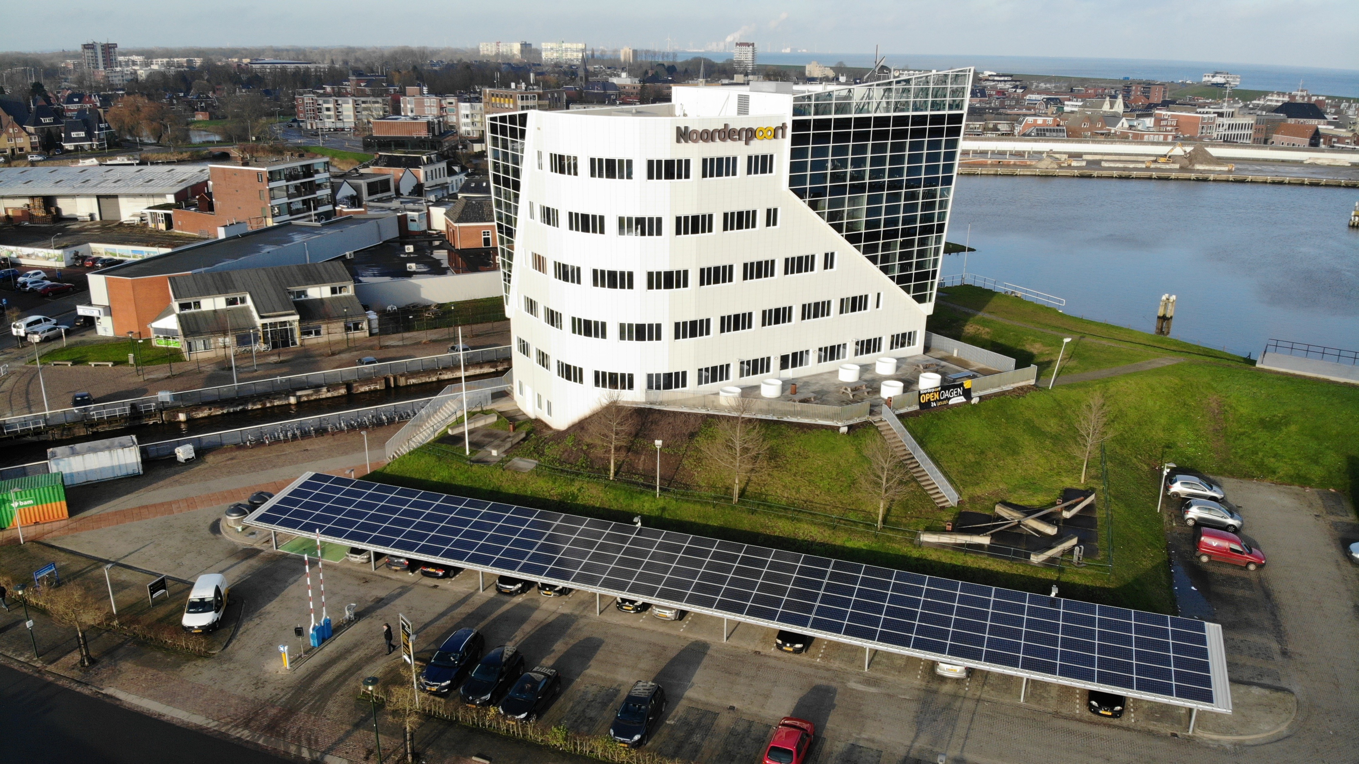 Het hoofdgebouw van Noorderpoort aan de Duurswoldlaan in Delfzijl nabij water en parkeerterrein.