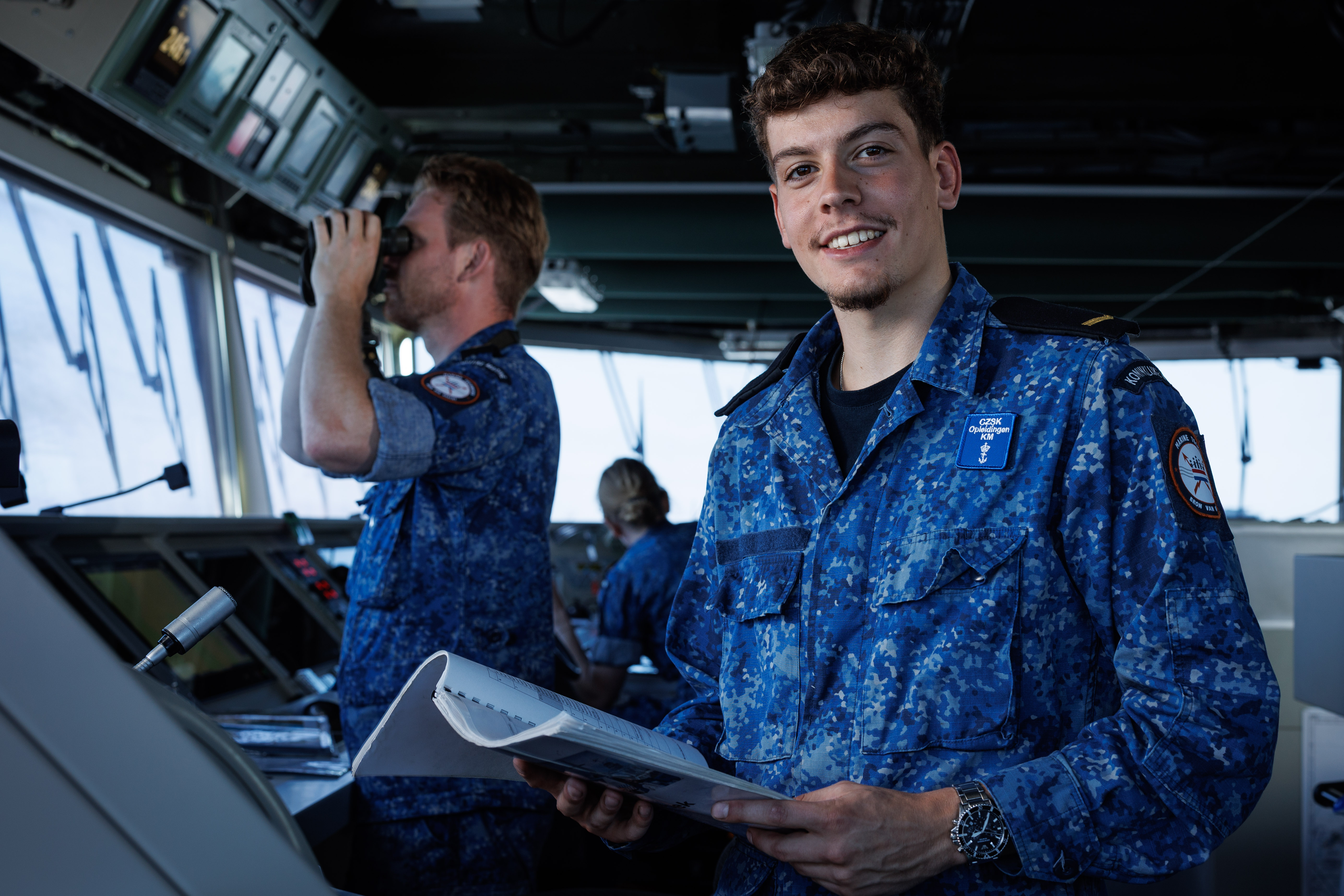 Student leert navigatie en communicatie aan boord van een schip in praktijkgerichte opleiding.