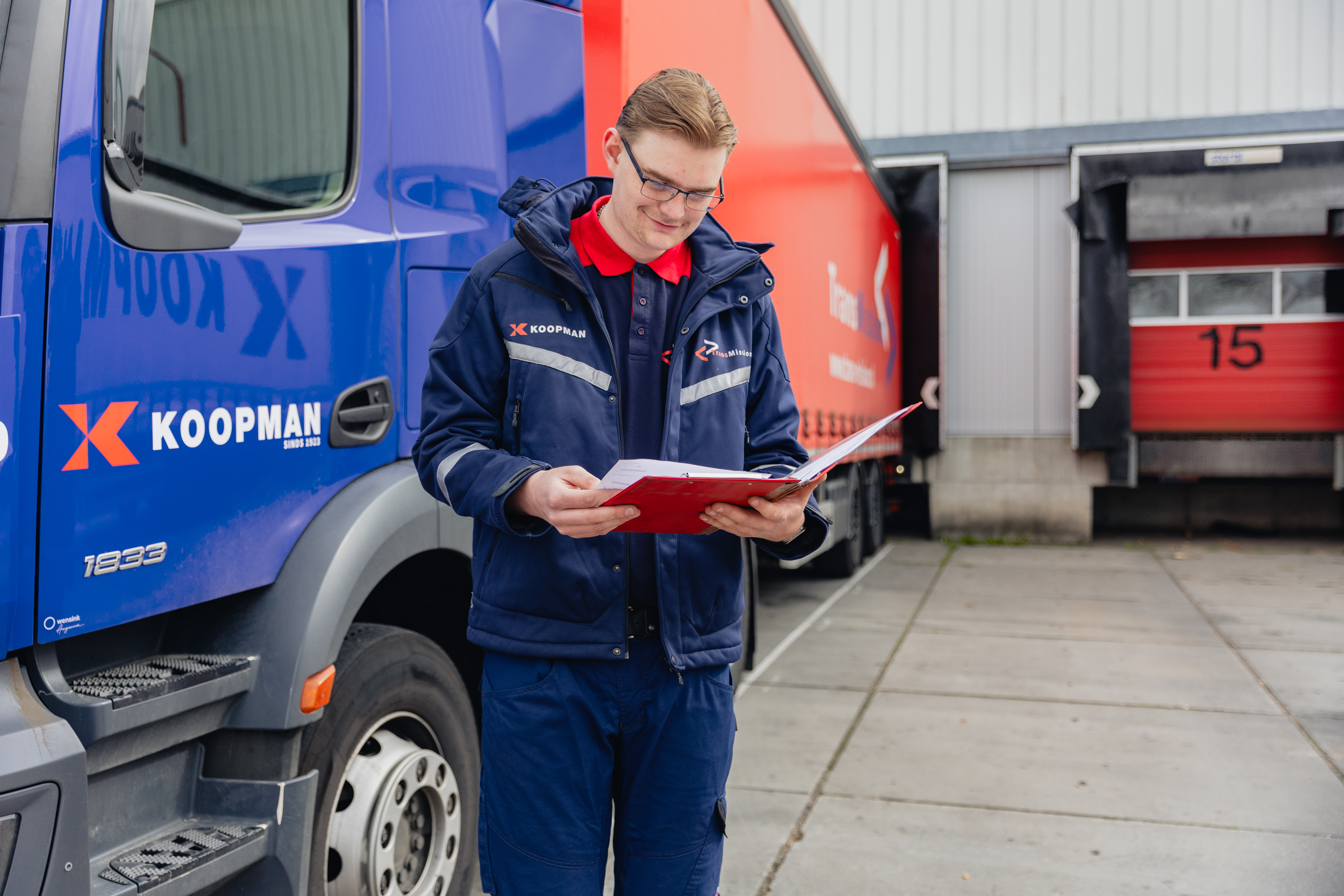 Logistiek medewerker controleert planning en documenten bij een koeltransporteur tijdens stage.